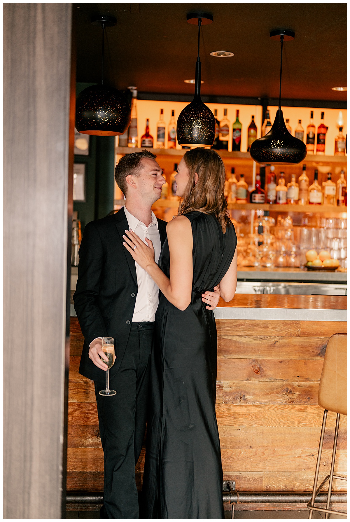 fiance in black suit holds his bride to be at bar by Rule Creative Co