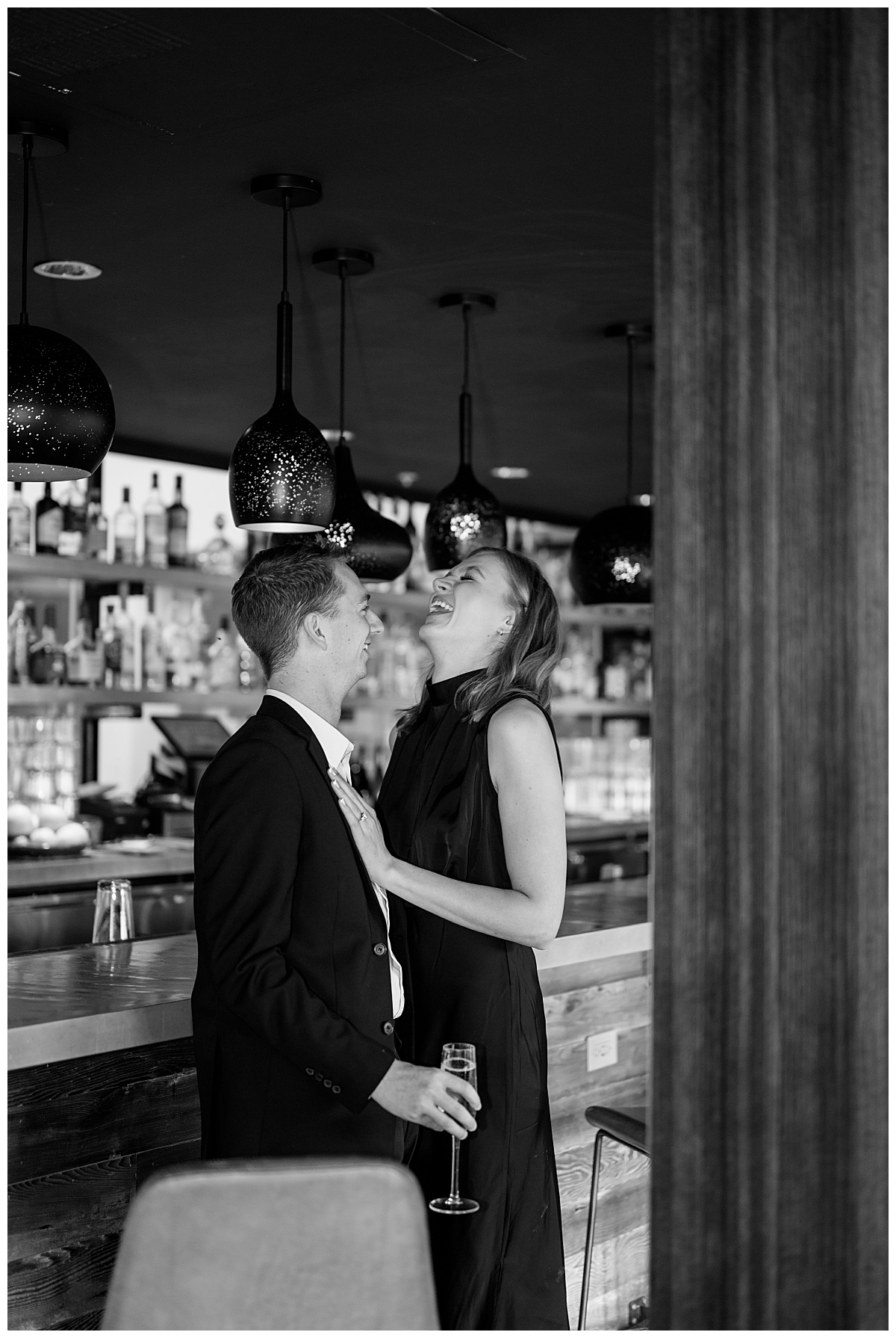 bride to be laughs at the bar with fiance by Minnesota wedding photographer 