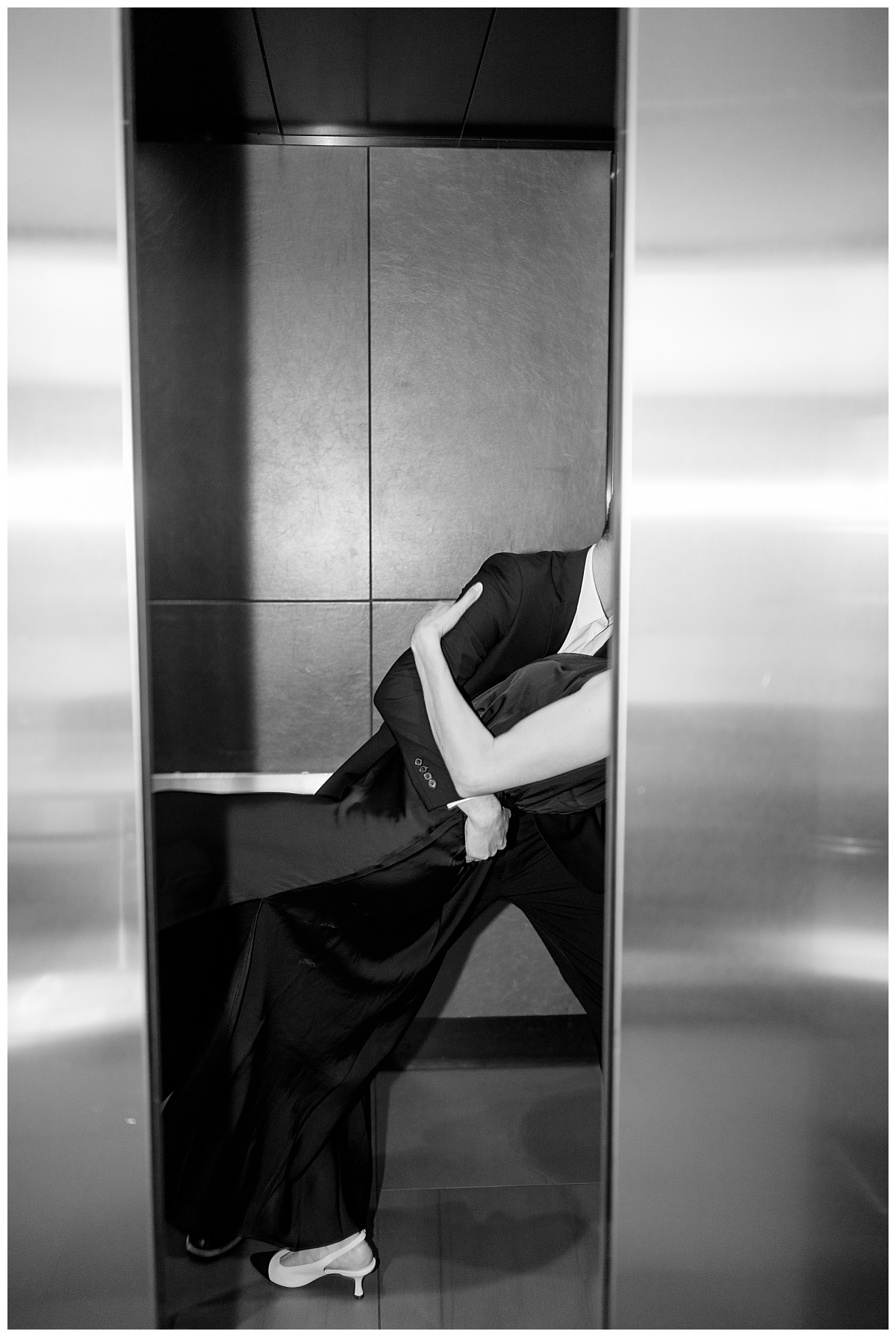 couple dip in elevator for a kiss by Rule Creative Co