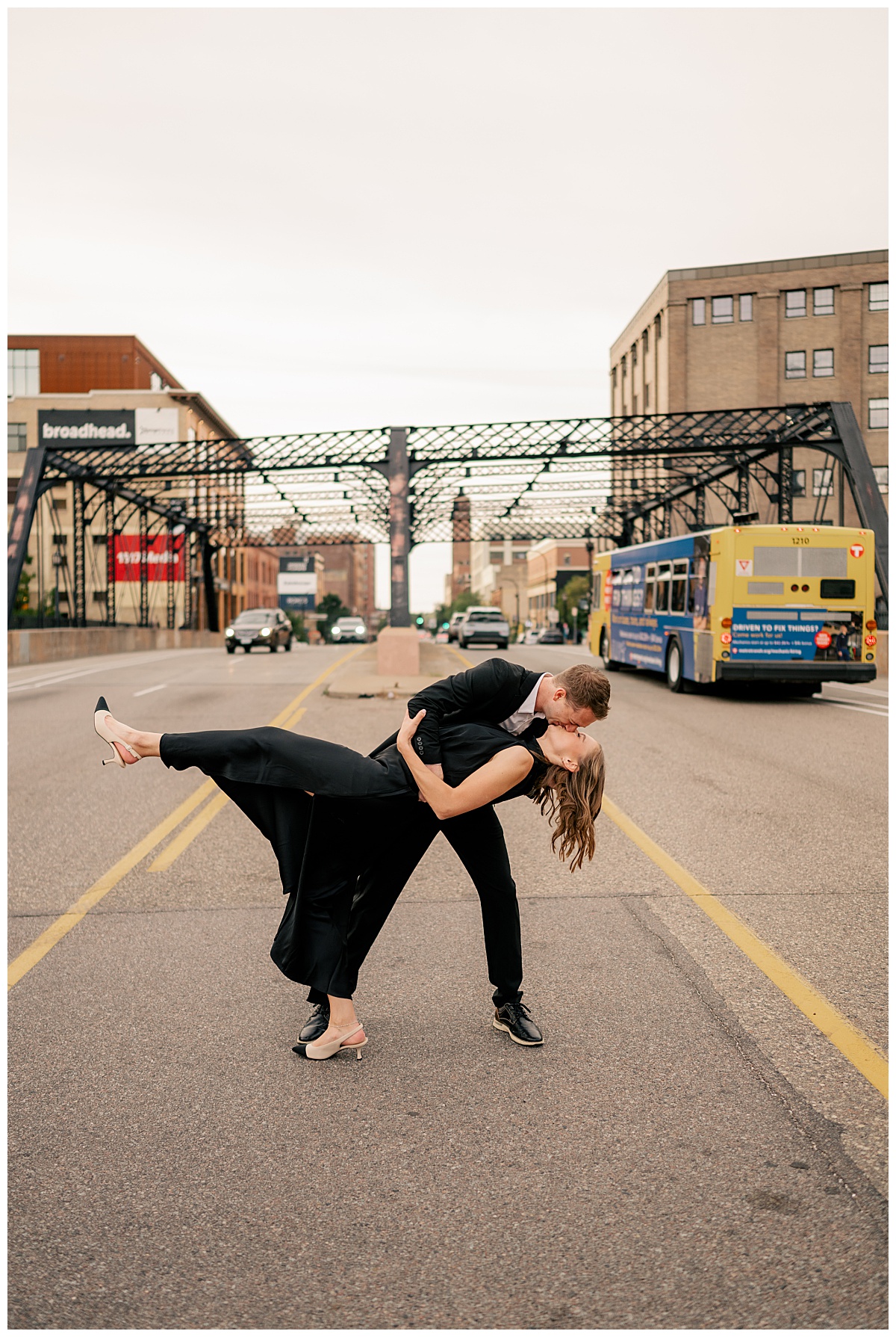 man in suit dips woman for kiss in the street at Hewing Hotel