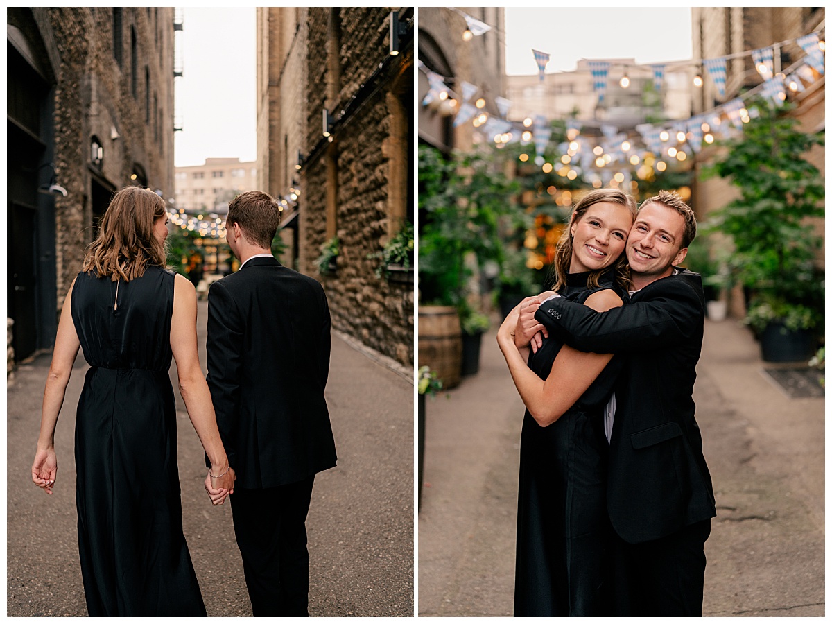 couple wearing all black hug in alley with flags & lights by Rule Creative Co