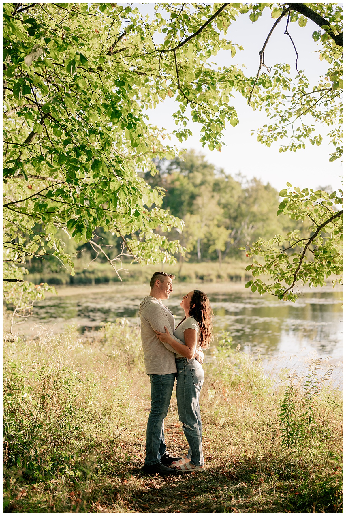 man hugs his bride-to-be by the lake by Rule Creative Co