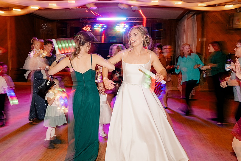 woman in white gown dances at reception by Rule Creative Co