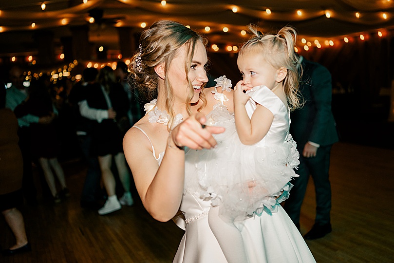 little flower girl hugging bride for Romantic Winter Wedding in Brooten