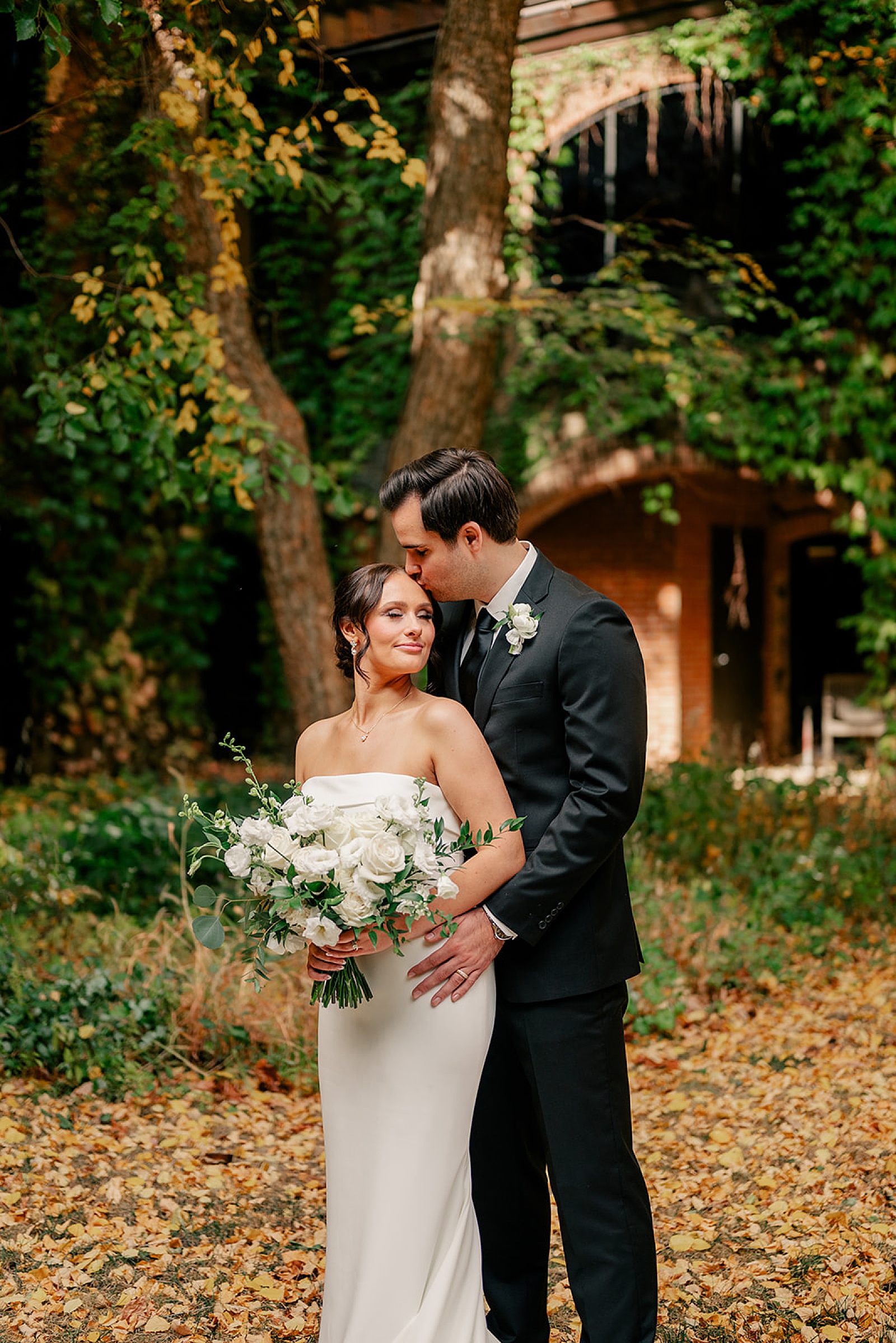 groom kisses bride on forehead during first look by Rule Creative Co