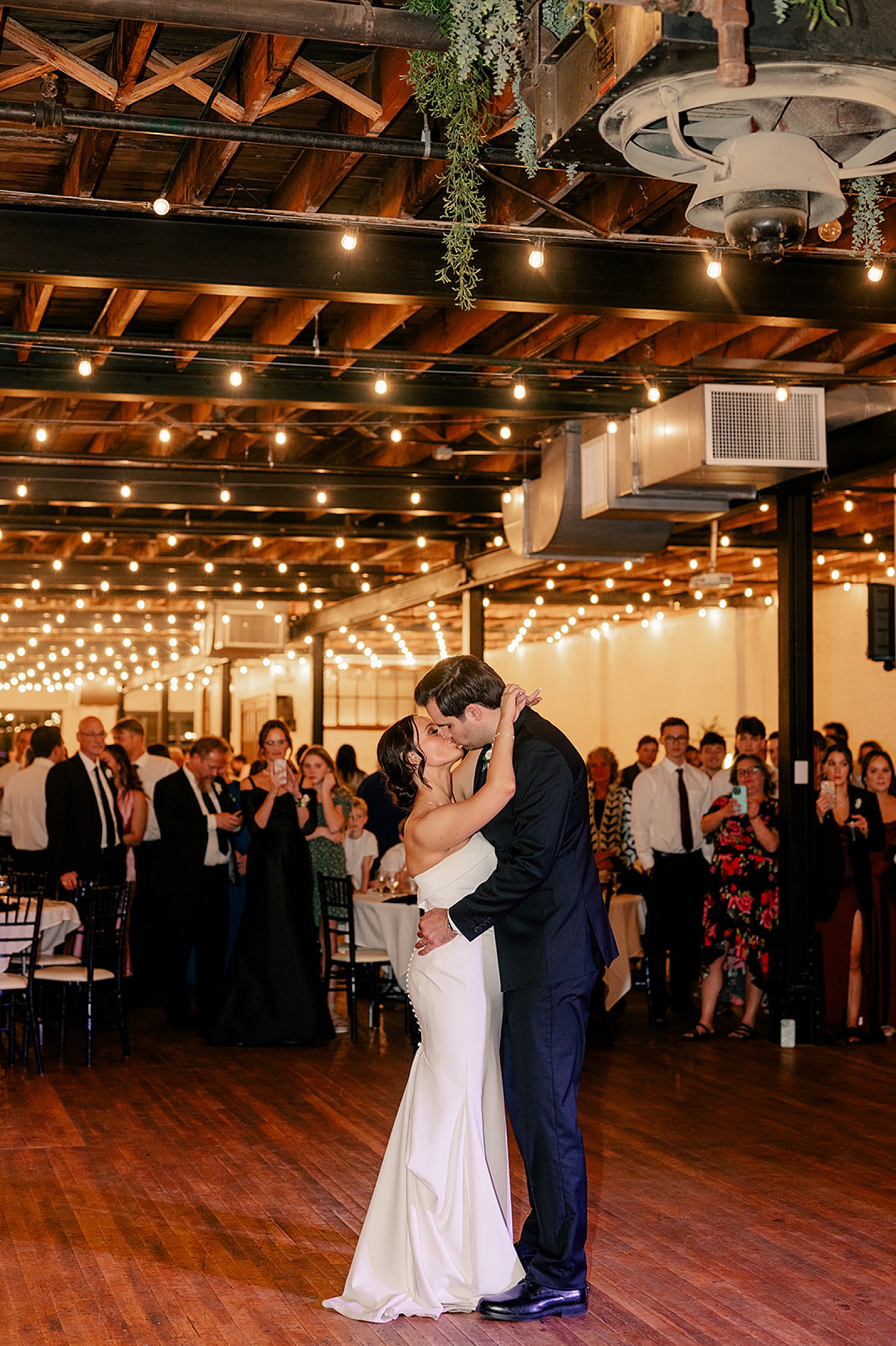 husband and wife share a kiss on dance floor by by Rule Creative Co