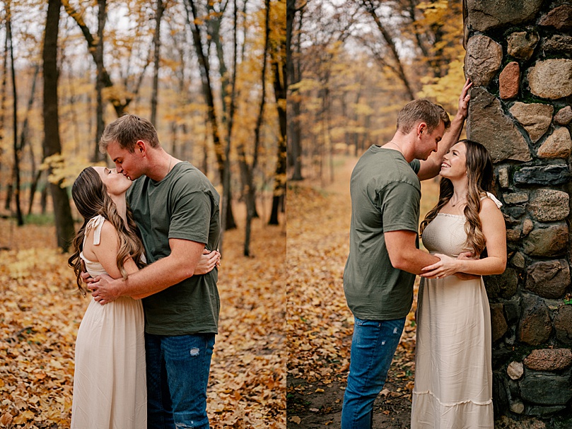 man leans over his bride to be who is against wall by Minnesota wedding photographer