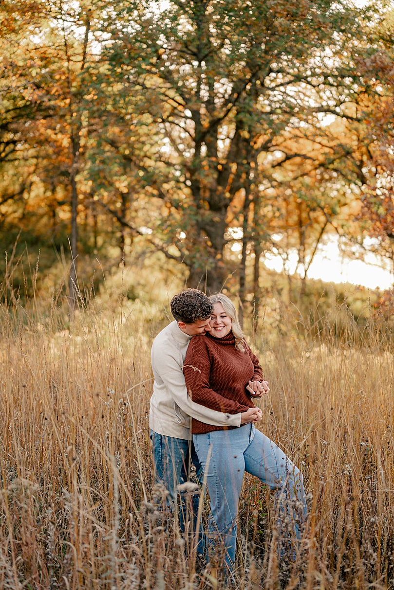 man kisses his fiancé for golden hour arboretum engagement session