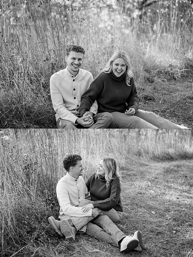 fiances giggling while sitting in tall grass by Minnesota wedding photographer