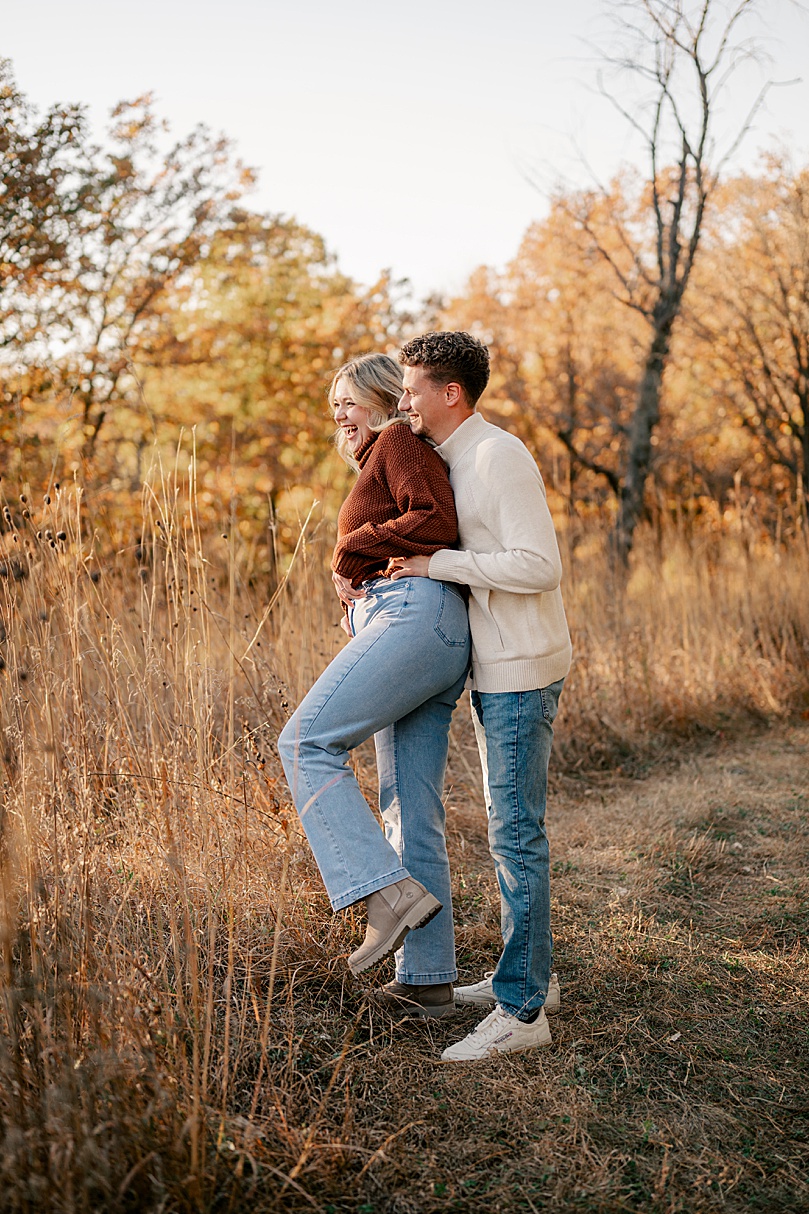 man and woman giggling in a field together by Rule Creative Co