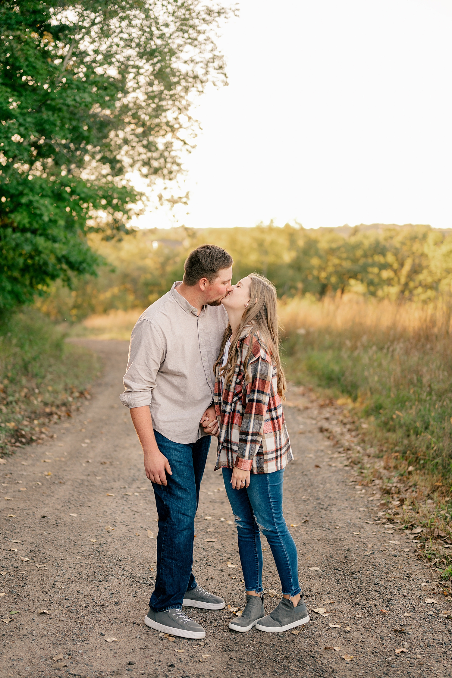 couple in plaid kiss on pathway by Rule Creative Co