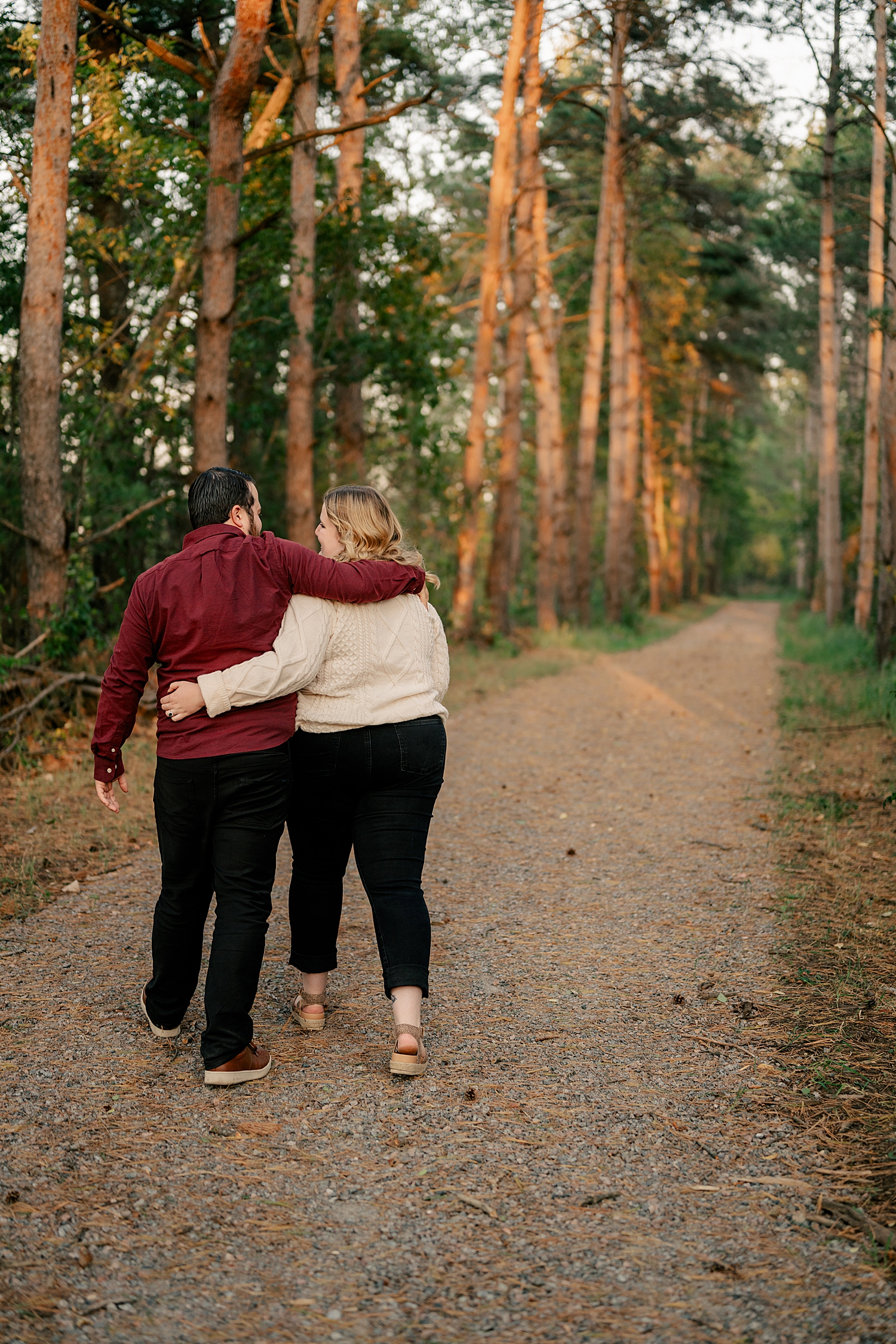 man and woman walk down path in woods by Rule Creative Co