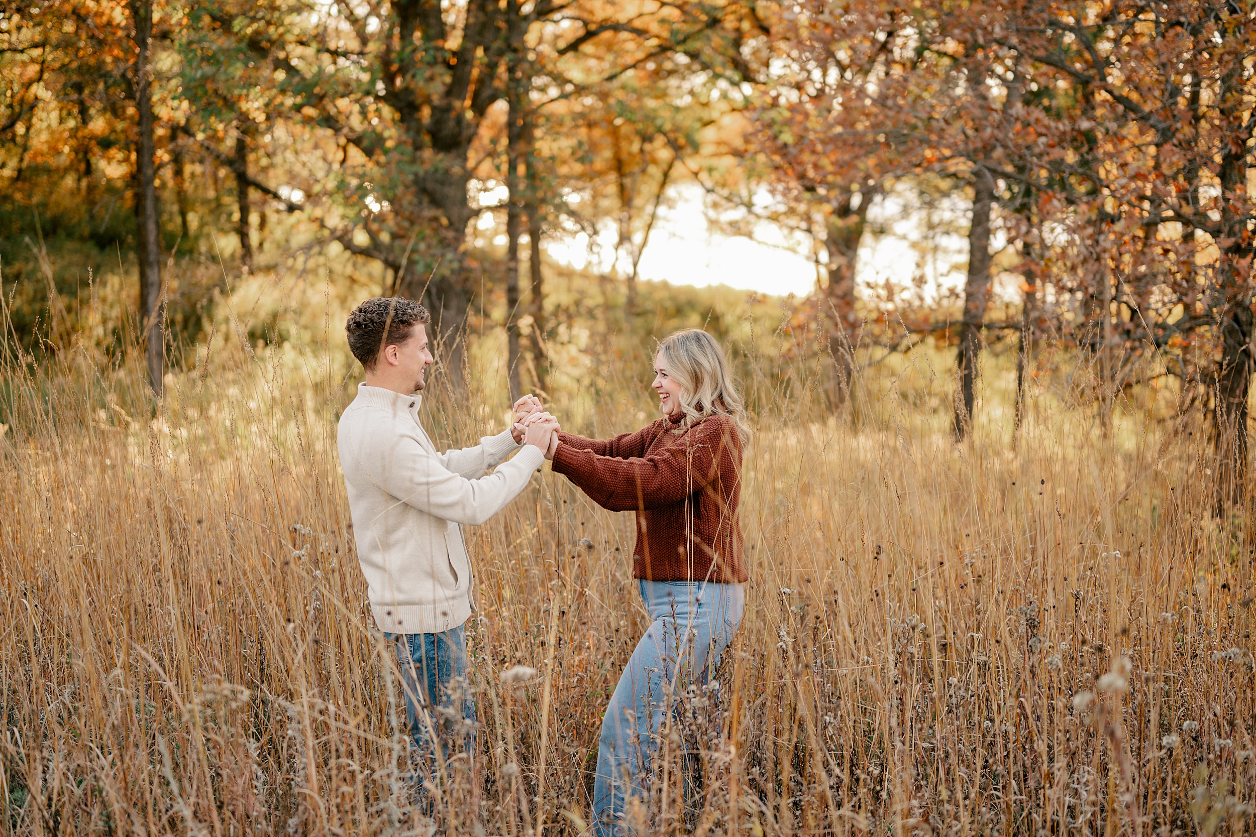 Couple holds hands during golden hour by Minnesota Wedding Photographer