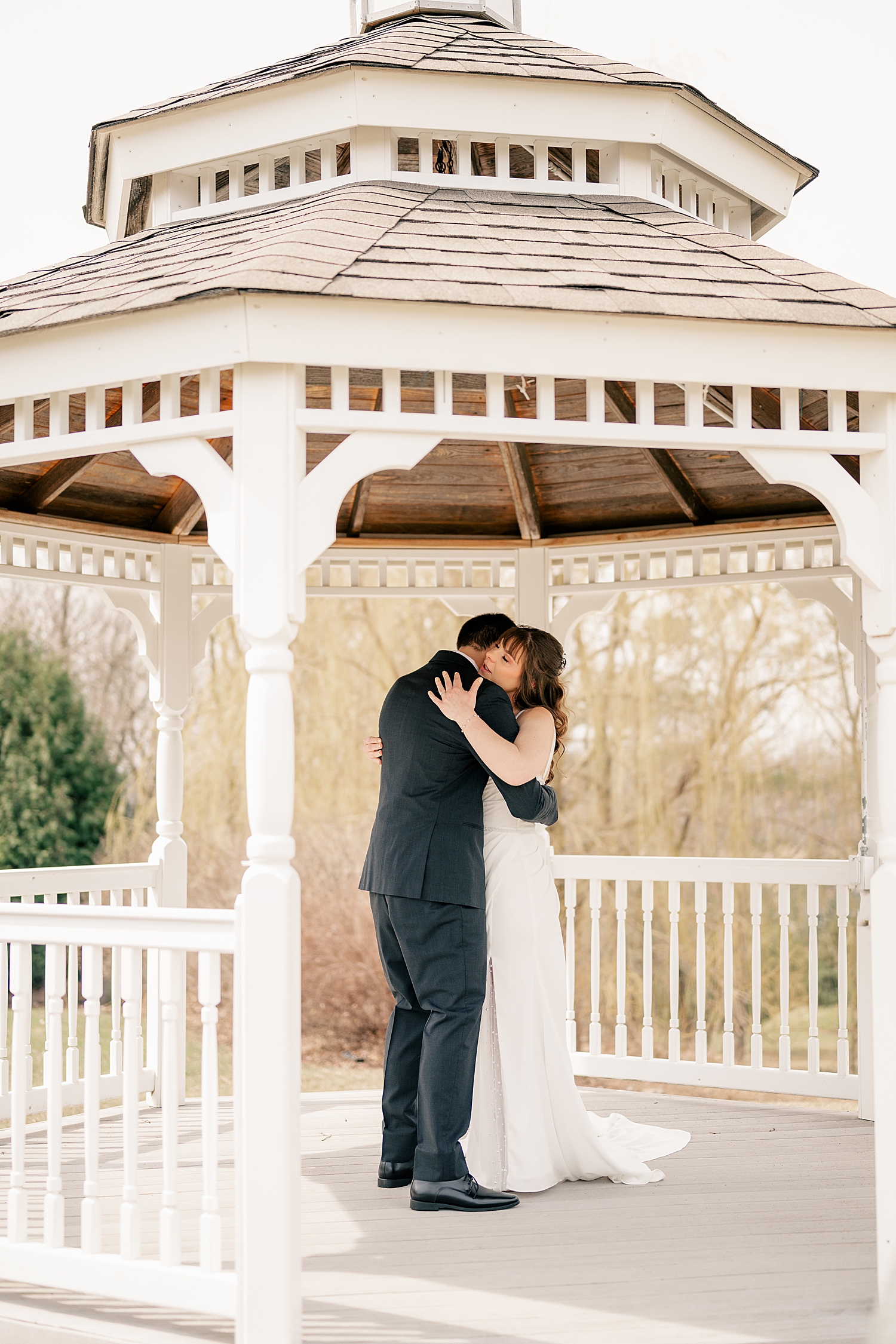 couple embraces in gazebo outside by Minnesota wedding photographer