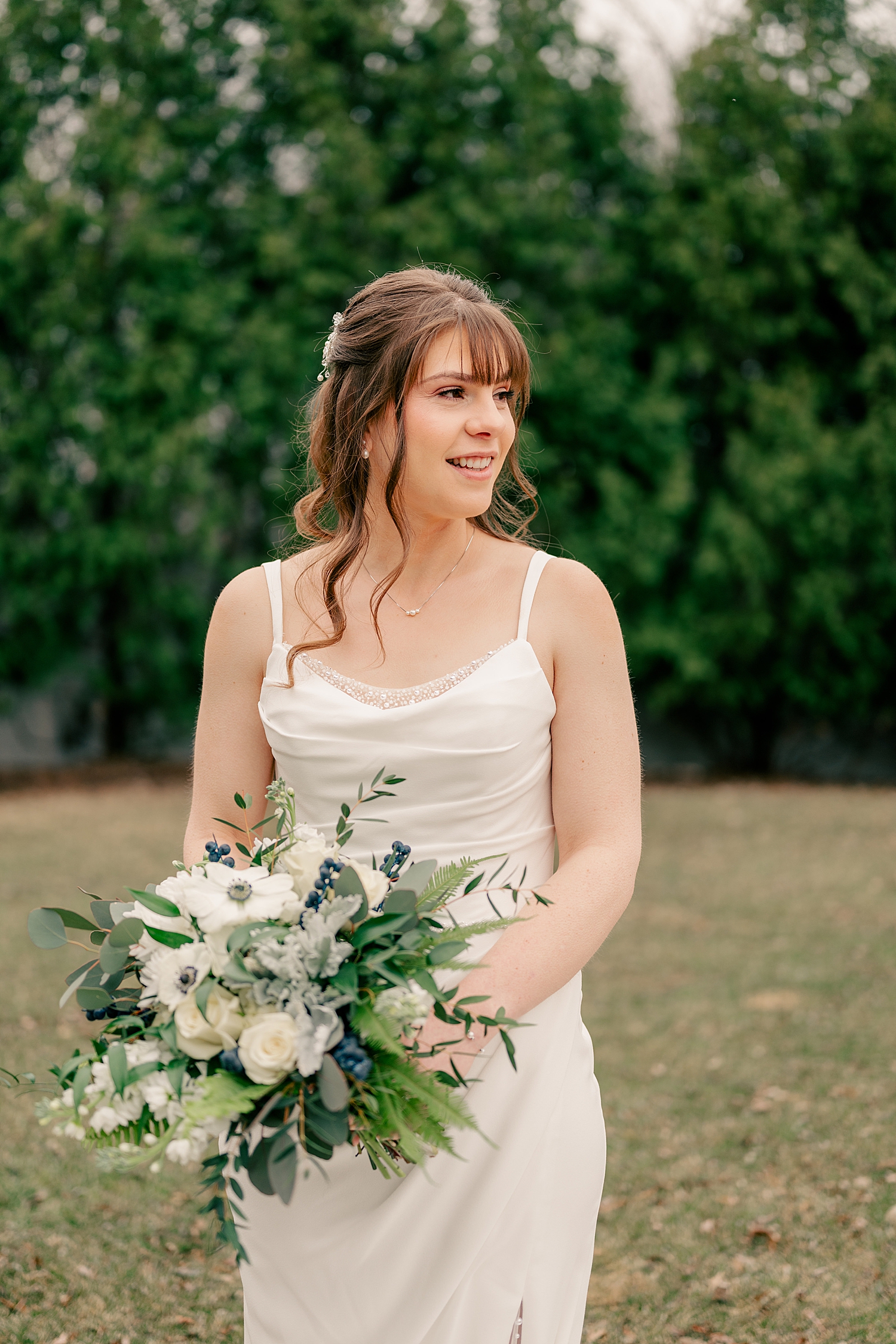 bride in simple white gown in garden by Minnesota wedding photographer