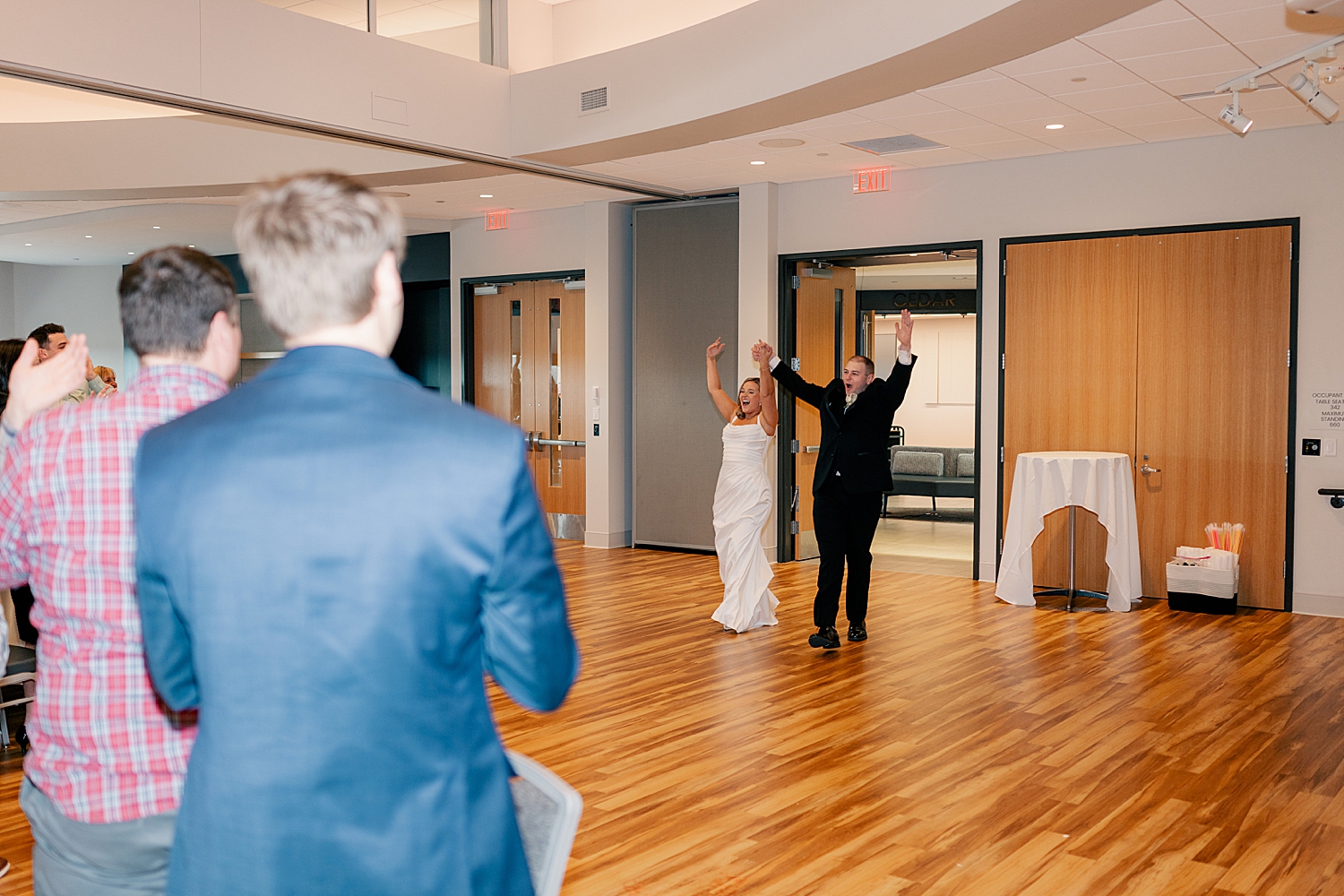 newlyweds walk into reception by Minnesota wedding photographer