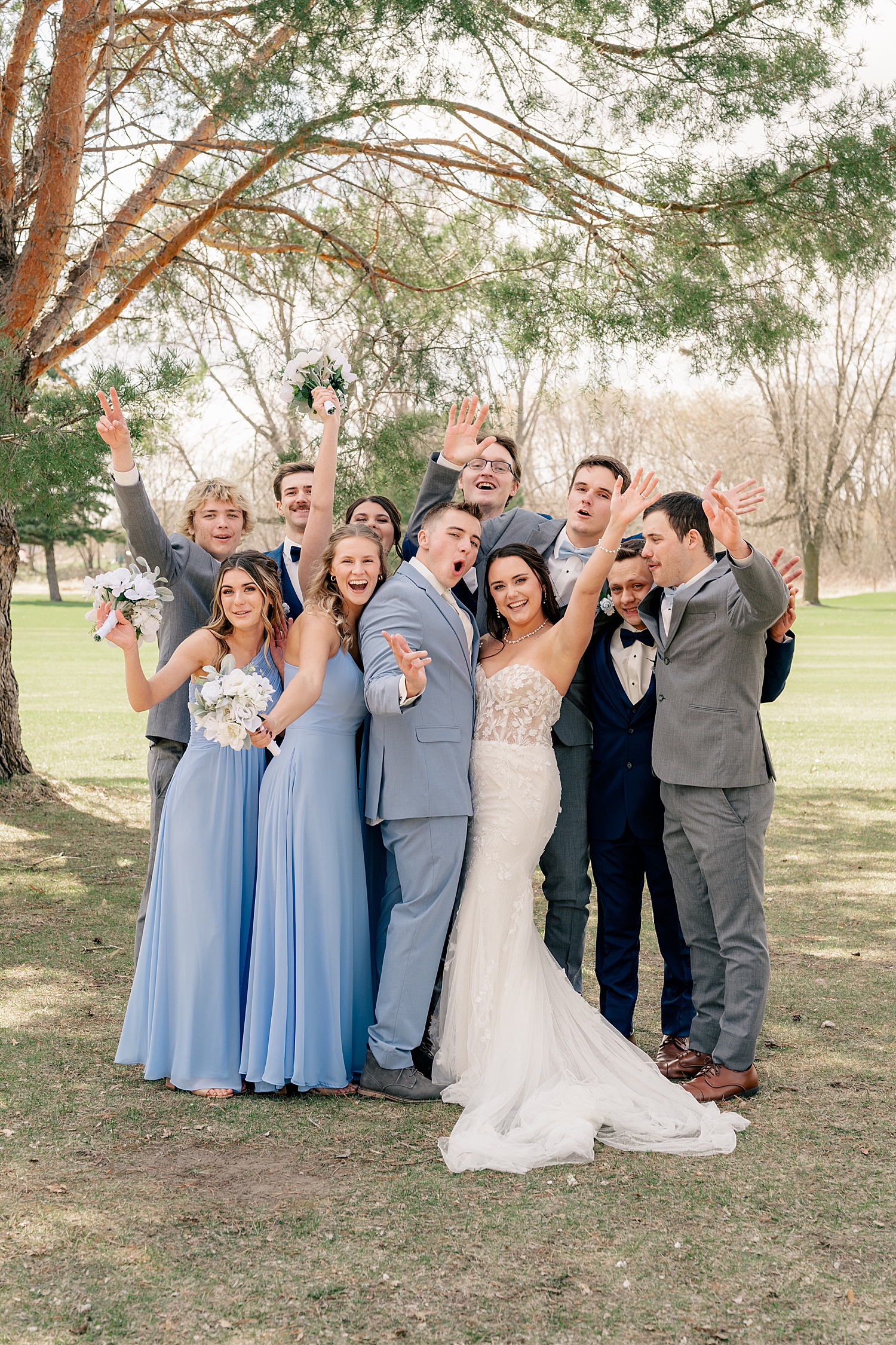 friends surround newlyweds after ceremony by Minnesota wedding photographer