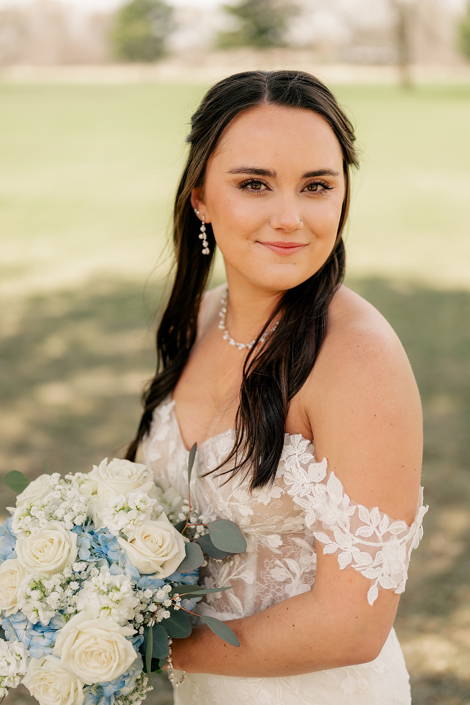 brunette woman in pearls and white gown by Minnesota wedding photographer