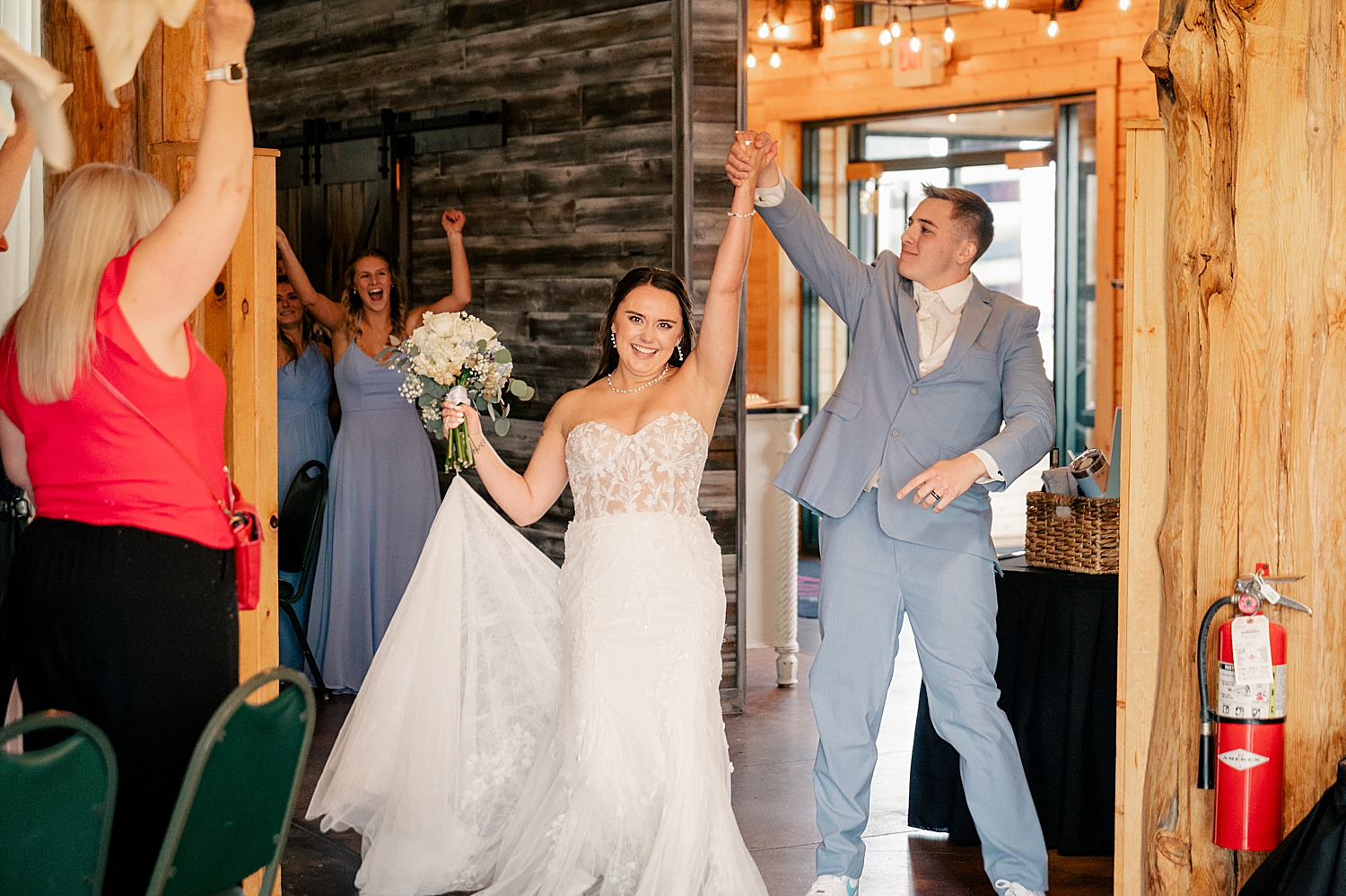 man and woman throw hands in air entering reception by Rule Creative Co