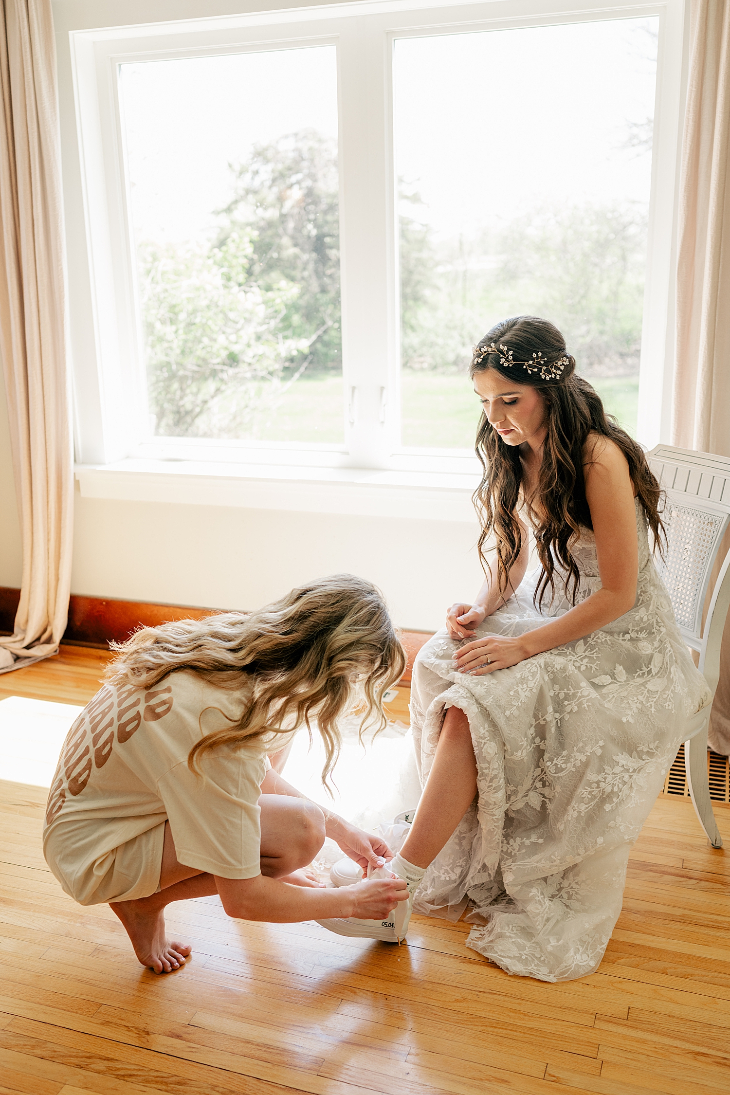 bride with floral headband gets tennis shoes on at The Cottage Farmhouse