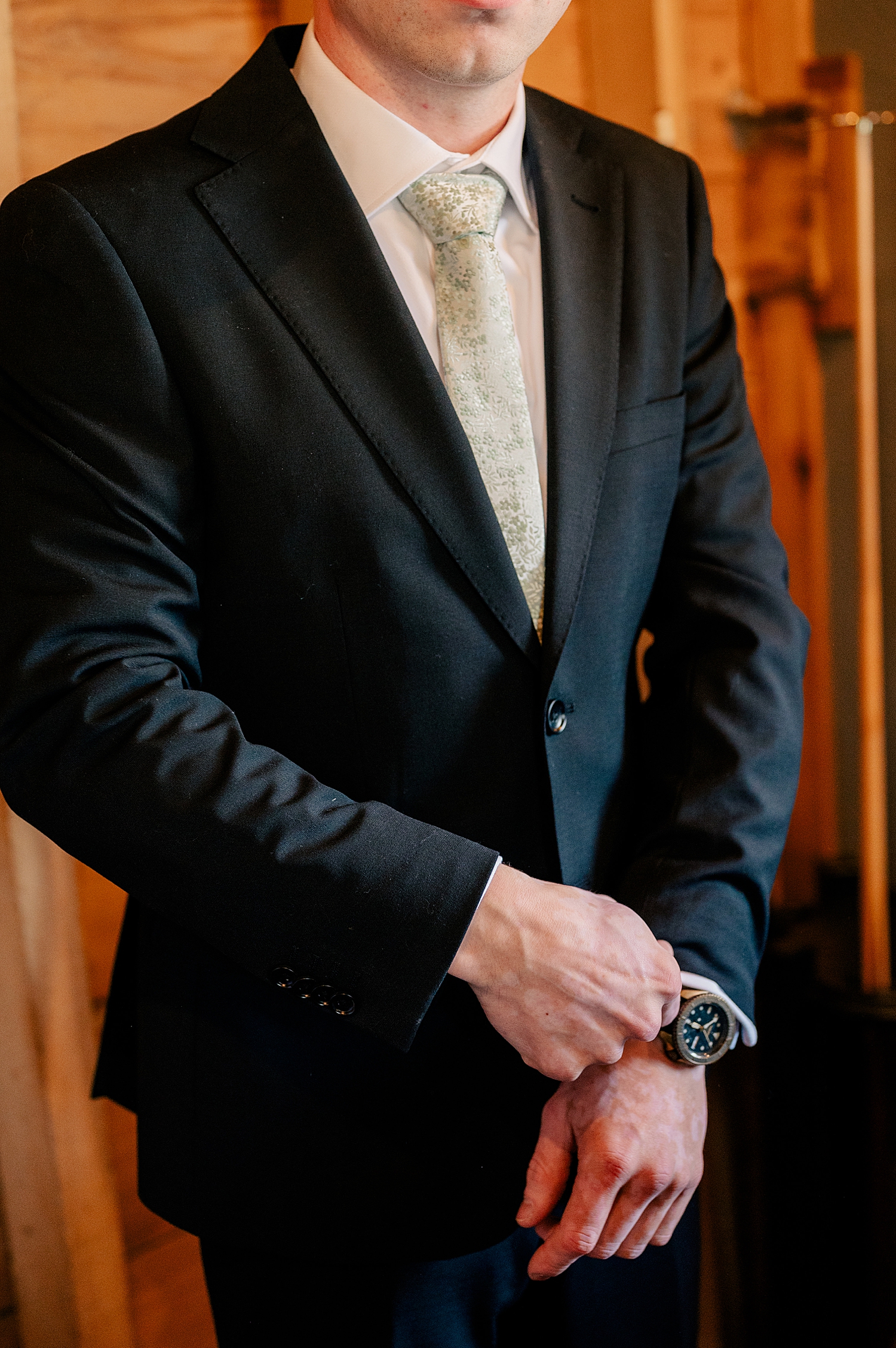 groom adjusts his suit before big day by Rule Creative Co