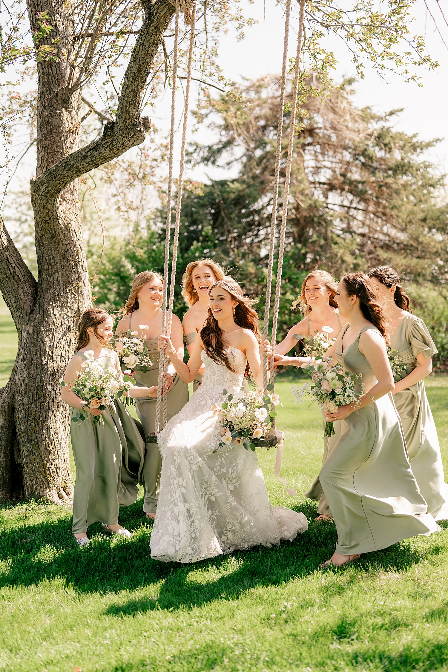 bridesmaids in green push woman on swing by Rule Creative Co