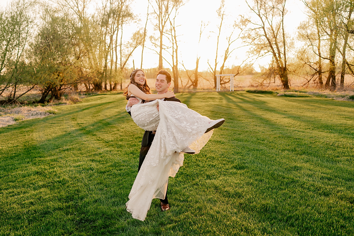 man twirls his new wife in golden hour in a field by Rule Creative Co