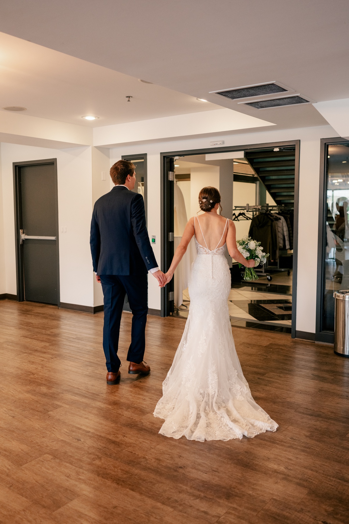 Minnesota Wedding Photographer captures bride and groom walking away from ceremony holding hands.