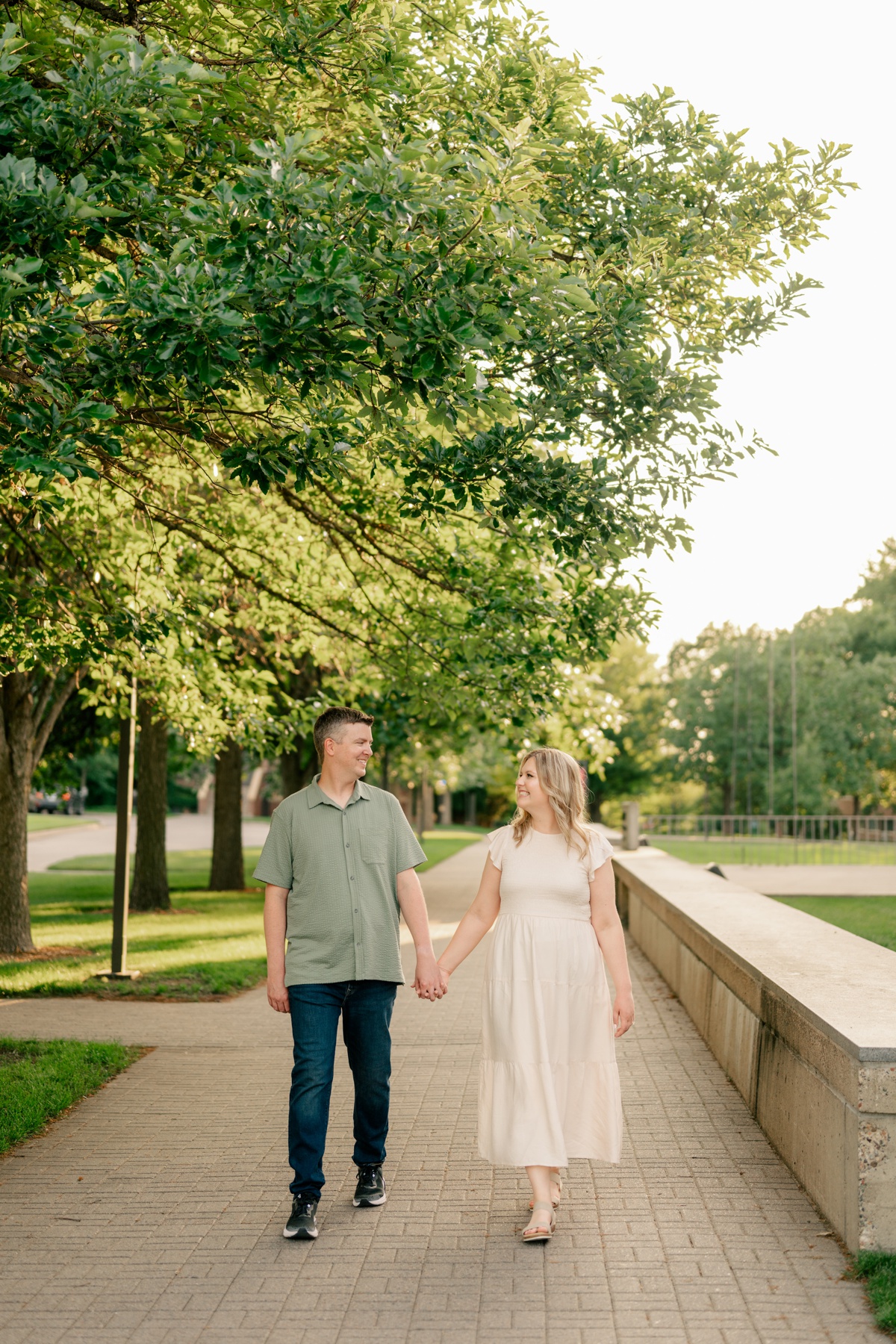 Man and woman hold hands and walk down sidewalk by Rule Creative Co.