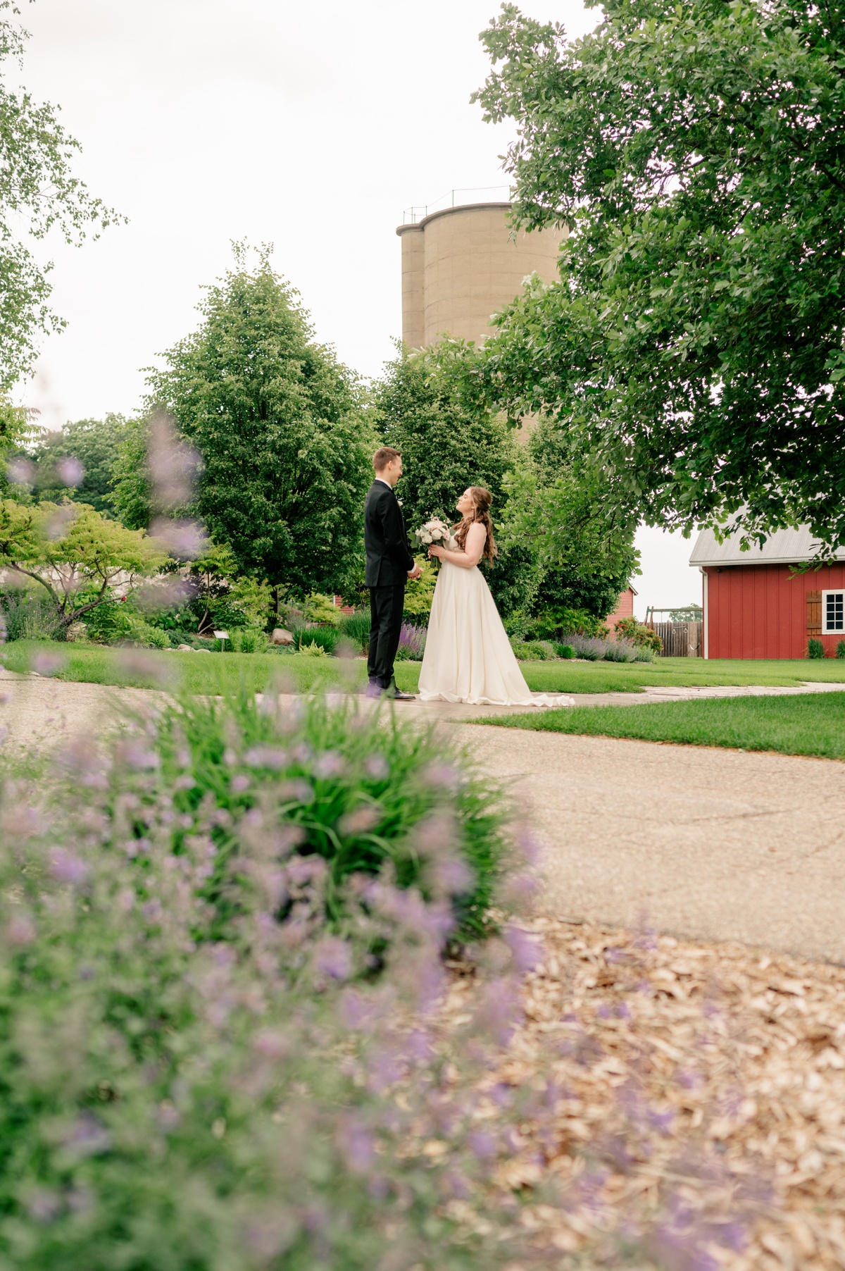 Bride and groom stand together in lavender garden during Baby's Breath Wedding