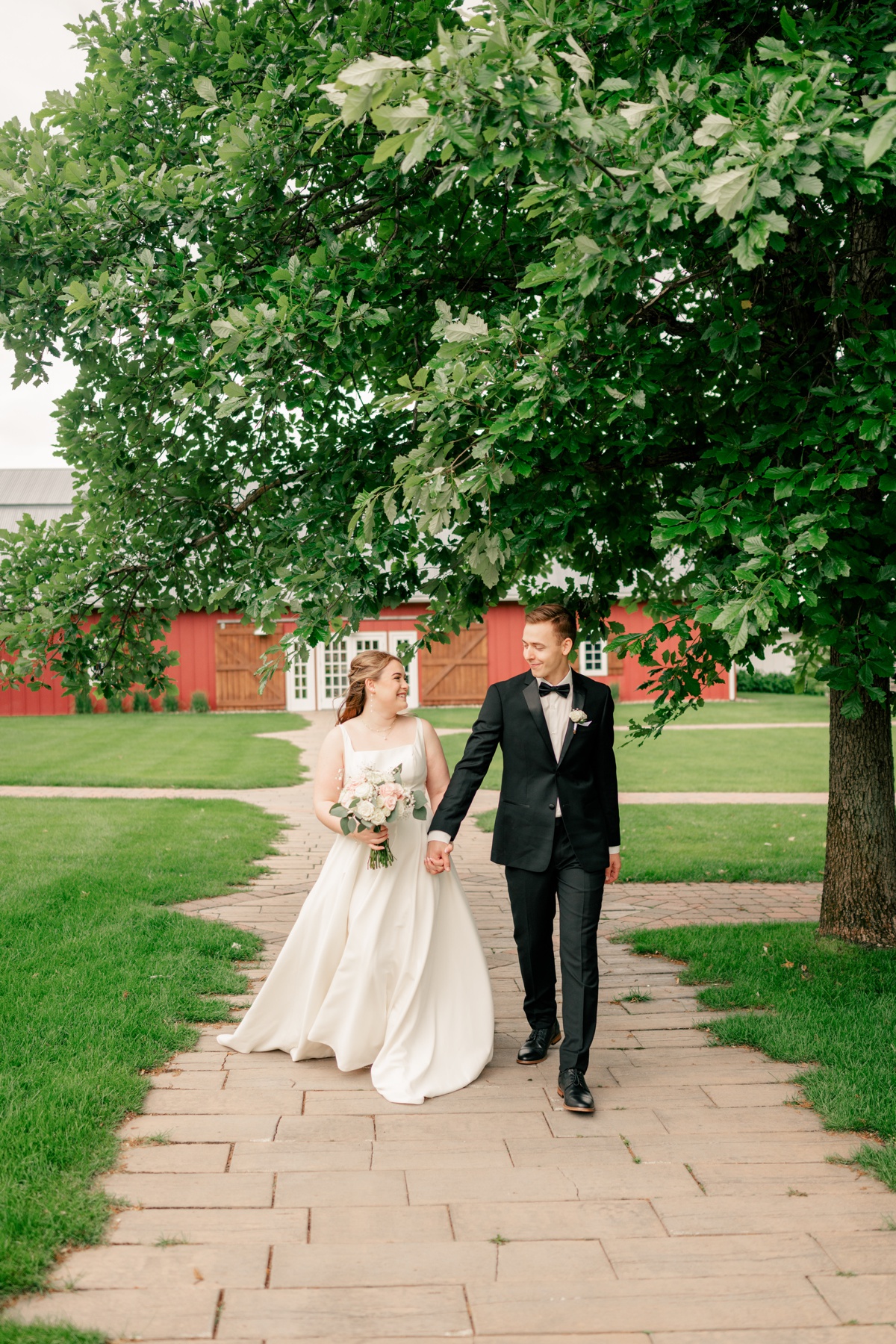 Bride and groom walking and holding hands by Rule Creative Co