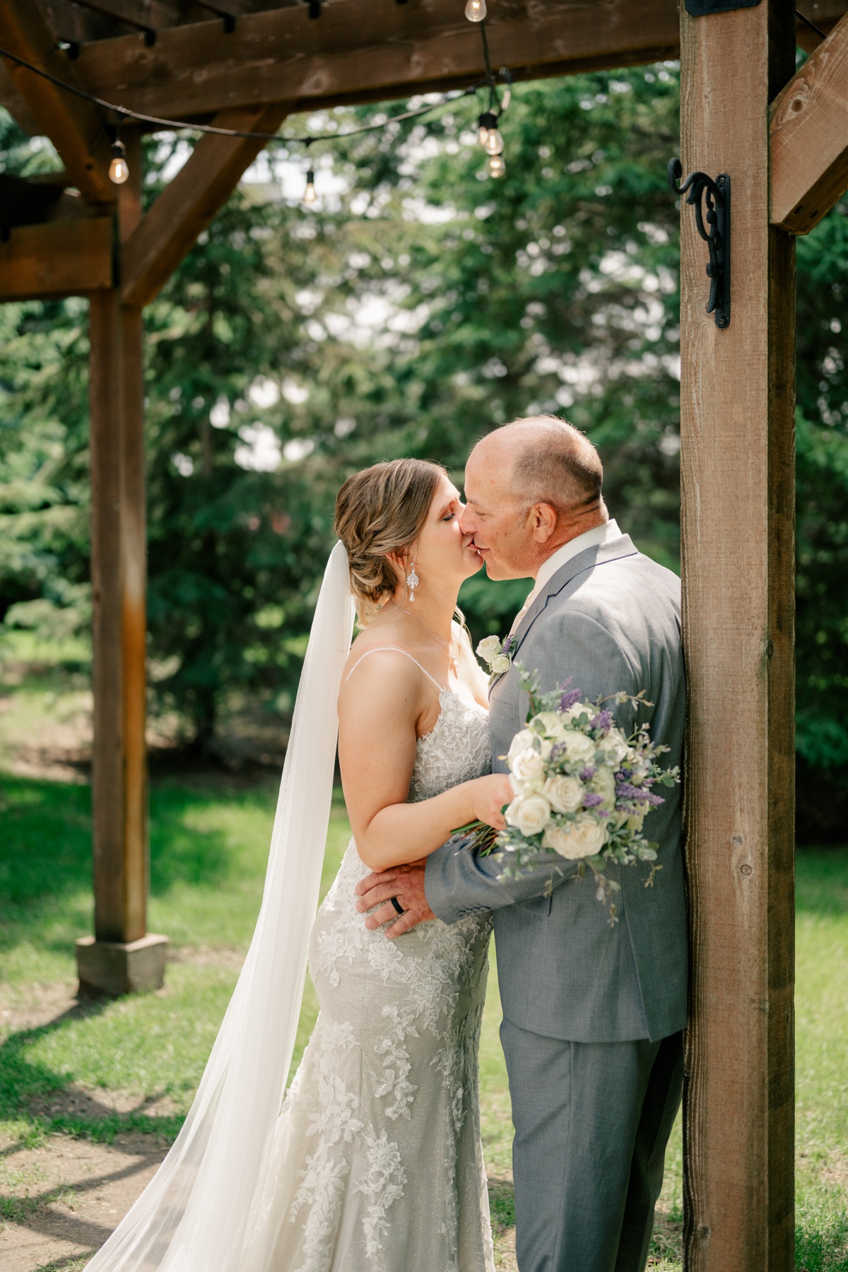 Minnesota Wedding Photographer captures newlyweds kissing under string lights