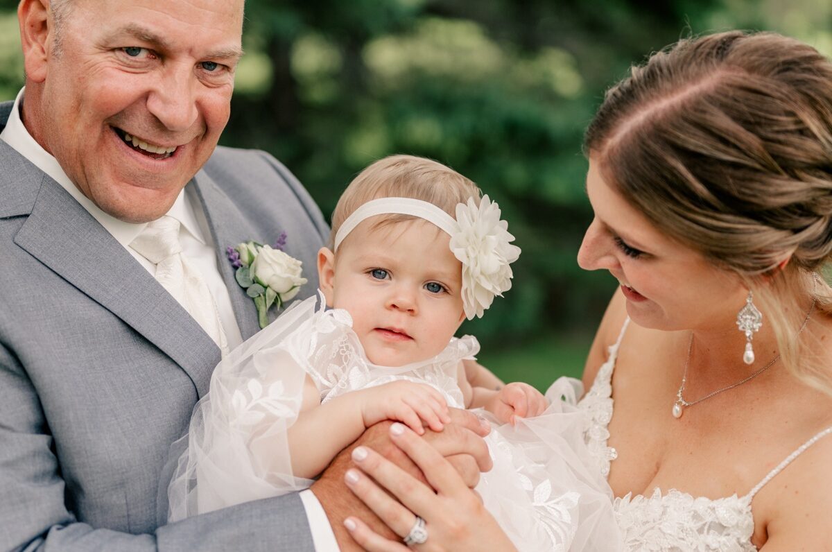 Bride and groom holding baby daughter by Rule Creative Co