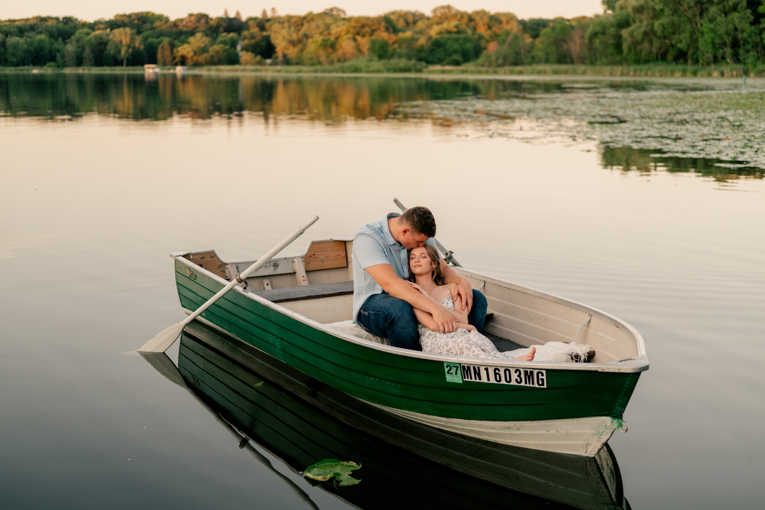 Couple sitting in boat on gentle pond by Rule Creative Co.