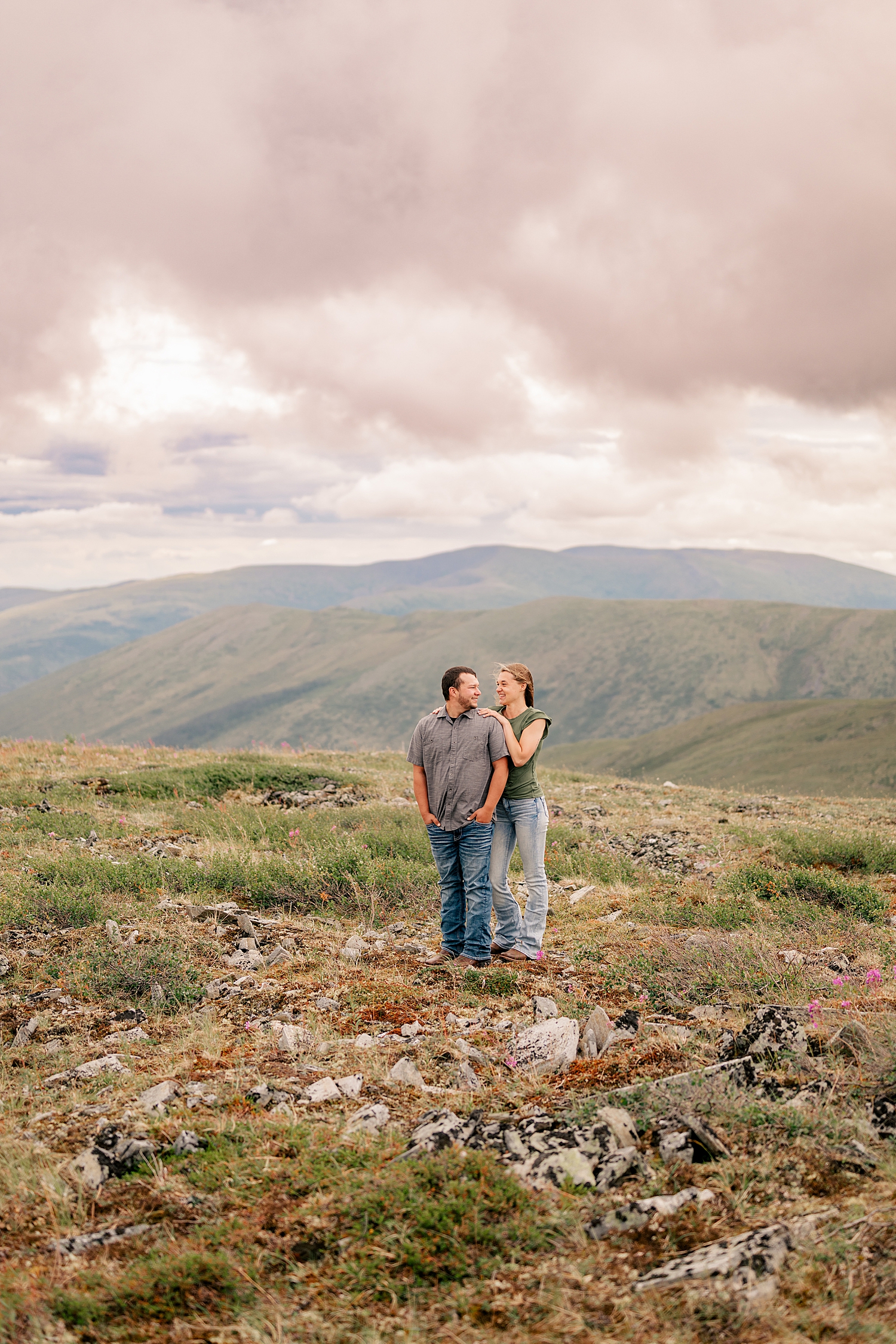 man and woman stand together with epic mountains behind them by Minnesota wedding photographer