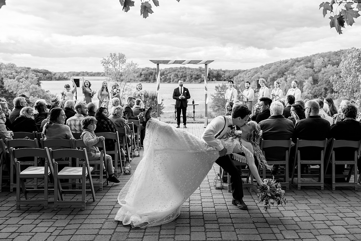 husband dips his new wife for a kiss after saying I Do at alter by Rule Creative Co
