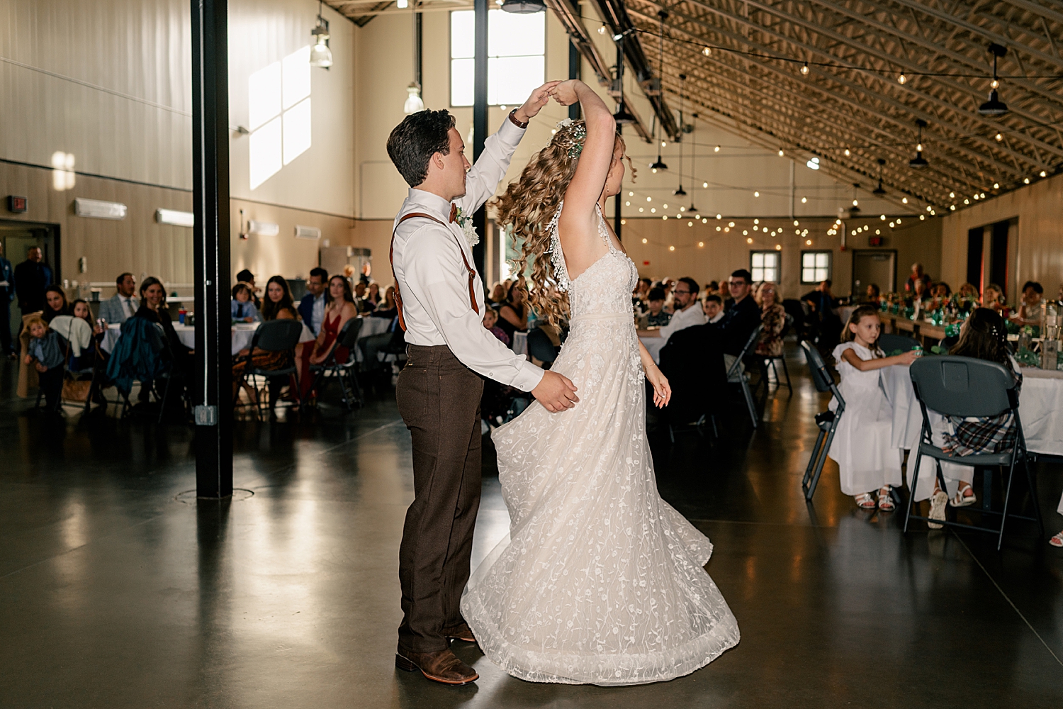 man spins his wife during their first dance at reception by Rule Creative Co
