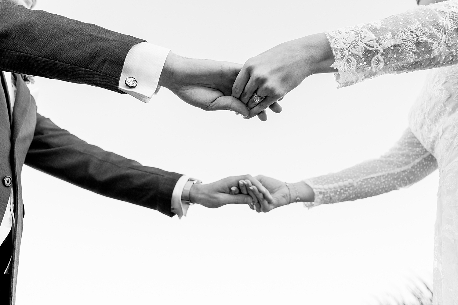 hands grasp each other over open space by Rule Creative Co