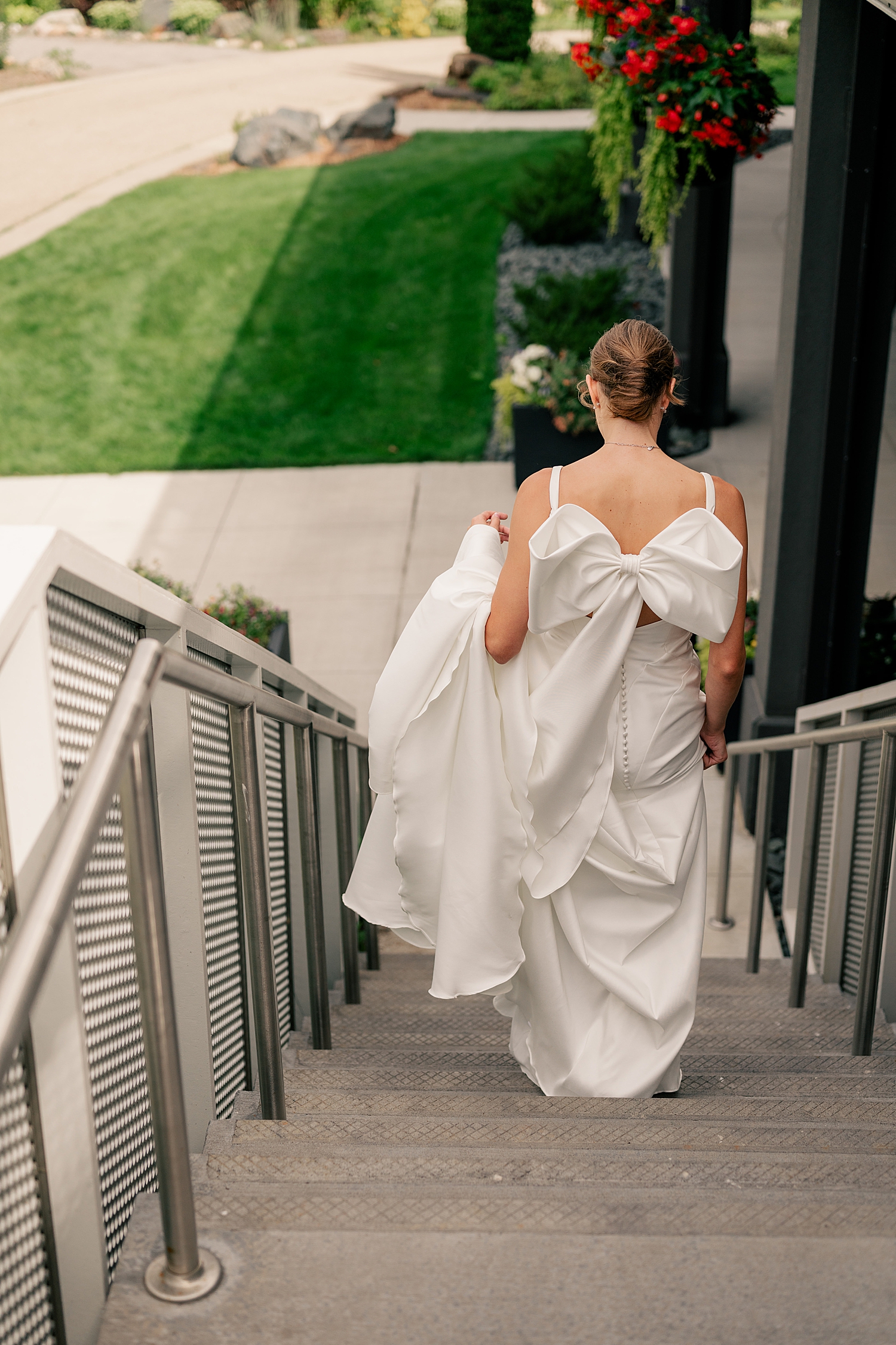 woman walks down steps in her white gown for first look by Minnesota photographer