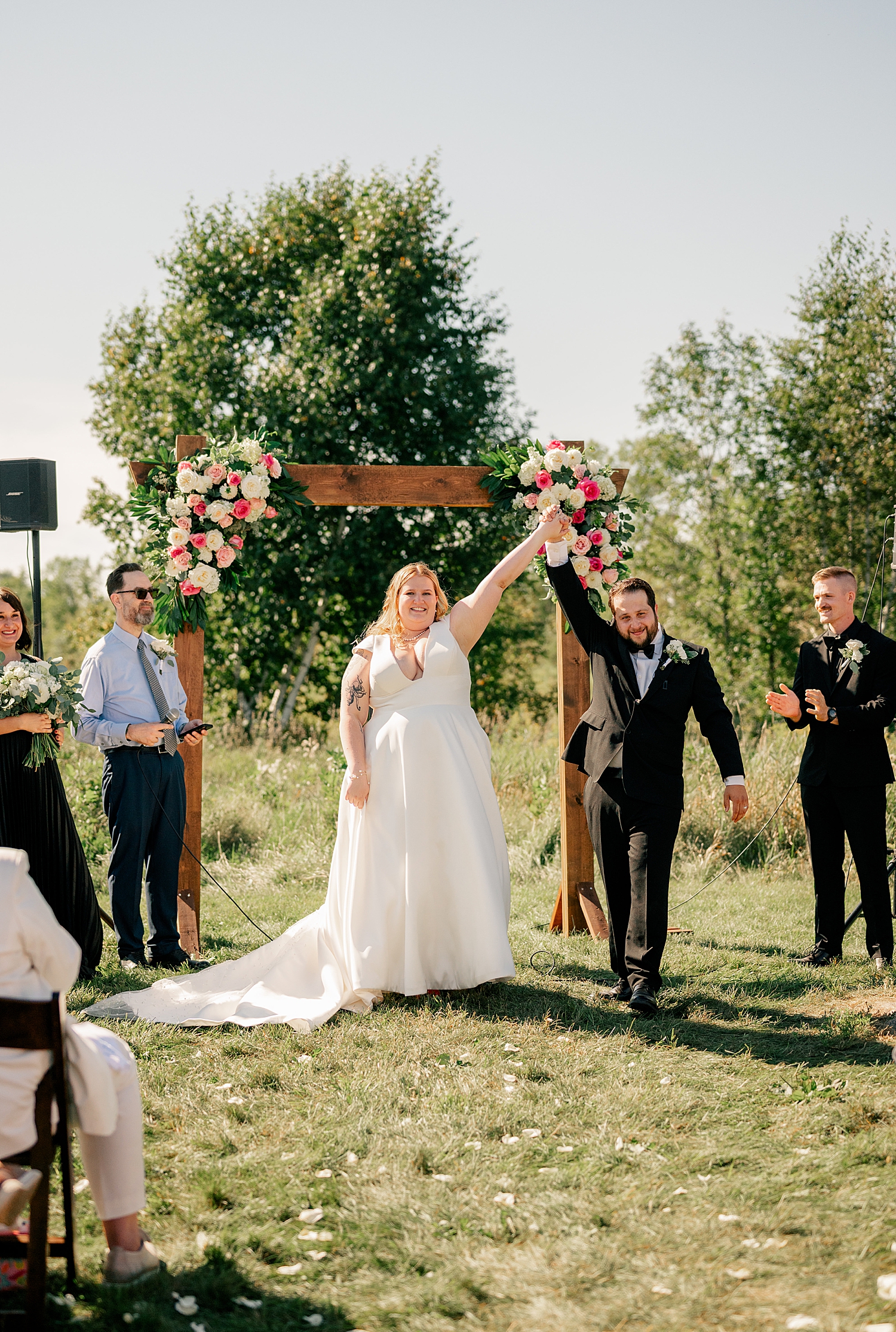 man and woman throw their hands up in celebration after ceremony by Minnesota elopement photographer