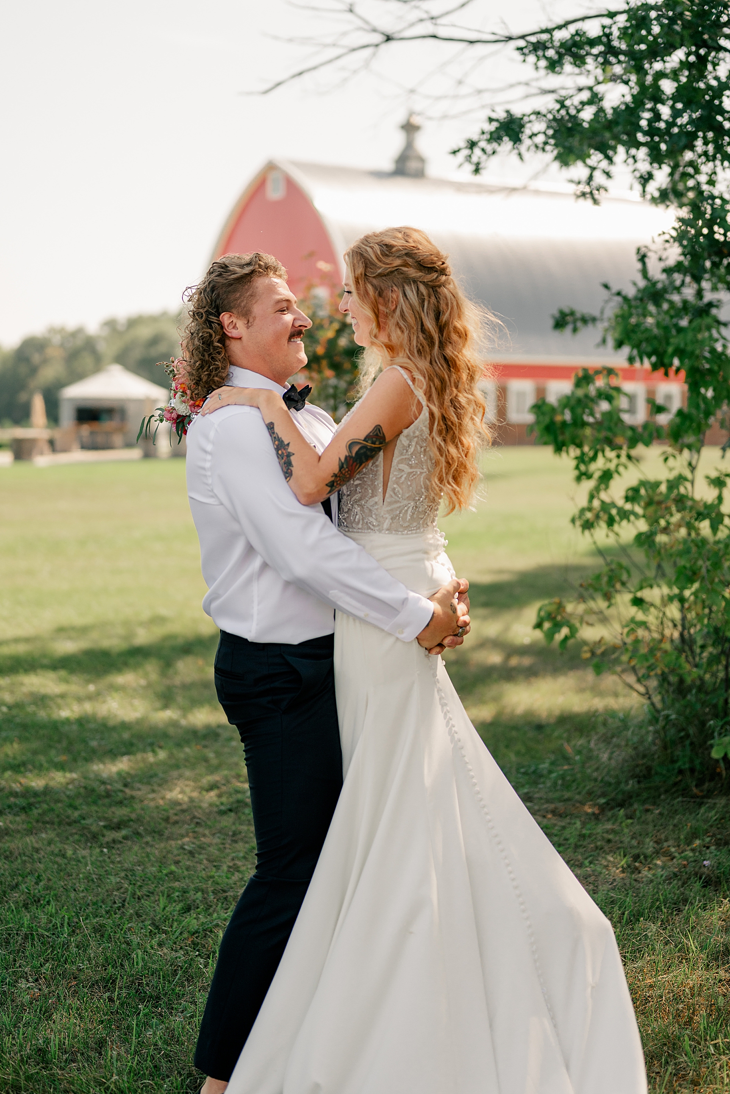 man with mullet picks up auburn bride by Minnesota wedding photographer