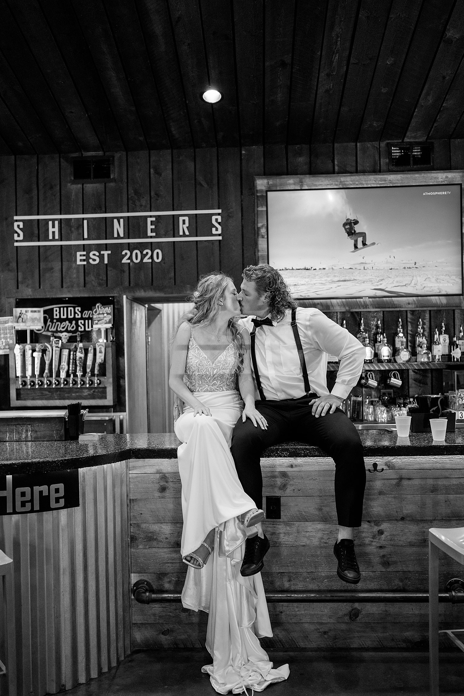 newlyweds sit on bar for social hour with their friends by Rule Creative Co