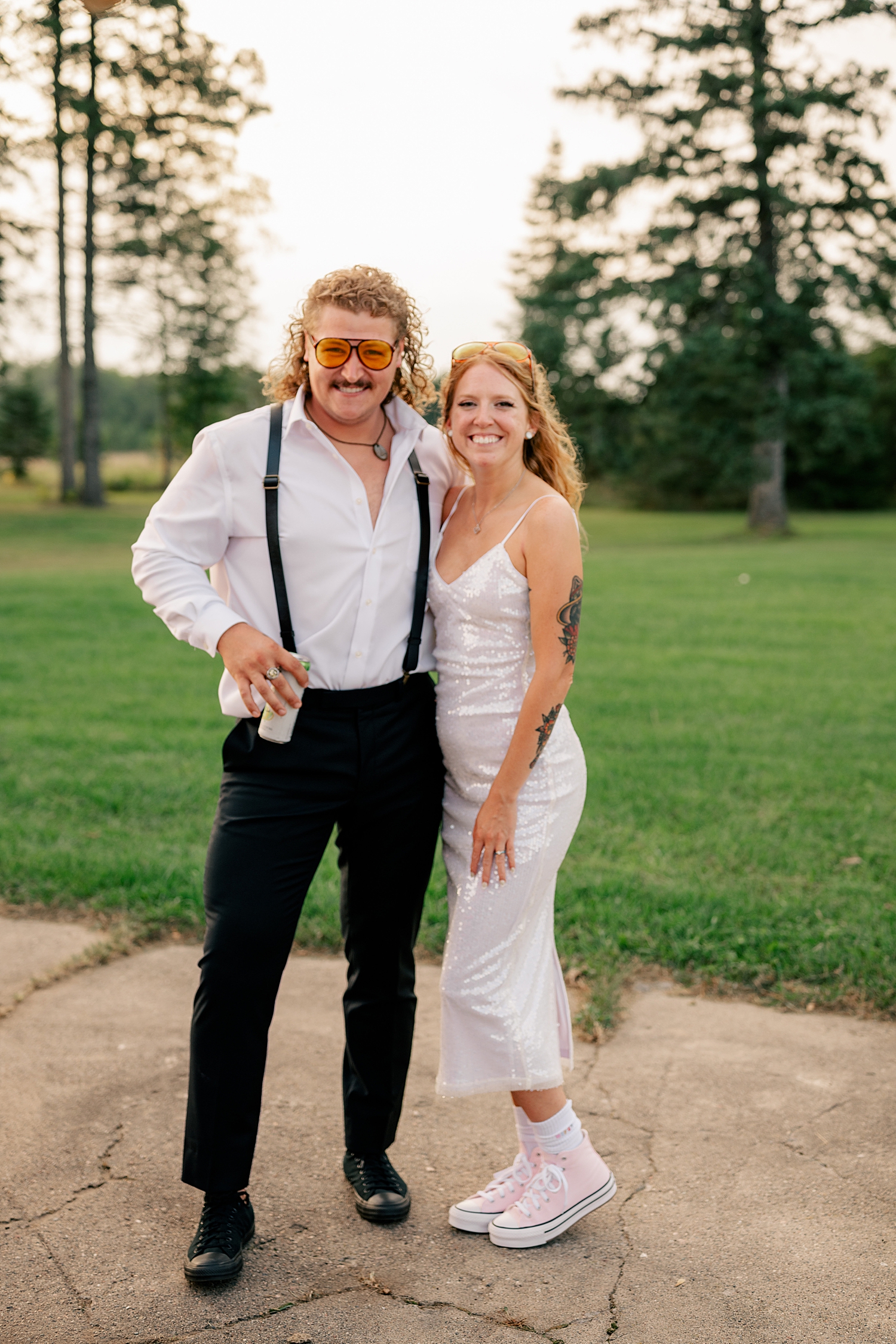 husband and wife stand on lawn in golden hour at Red Oak Farm