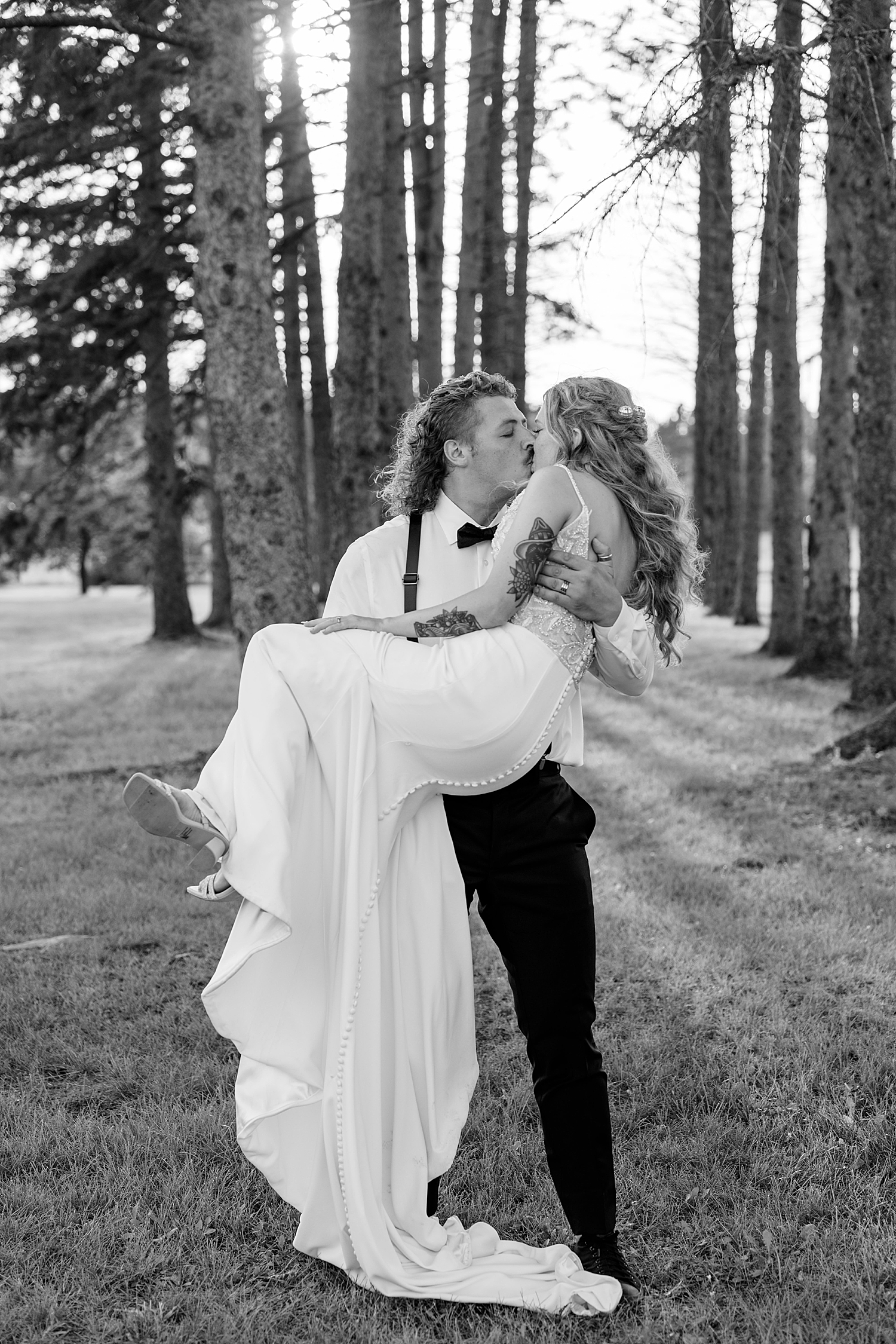 man carries his new wife through the trees by Rule Creative Co