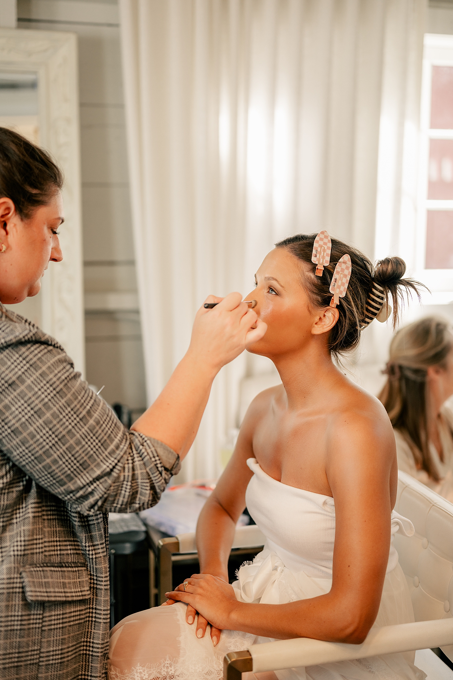 makeup artist applies concelear to bride by Minnesota wedding photographer