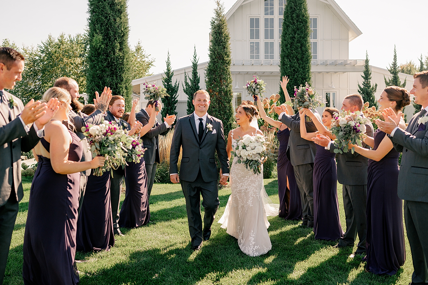 couple walk through lines of their friends cheering them on by Rule Creative Co