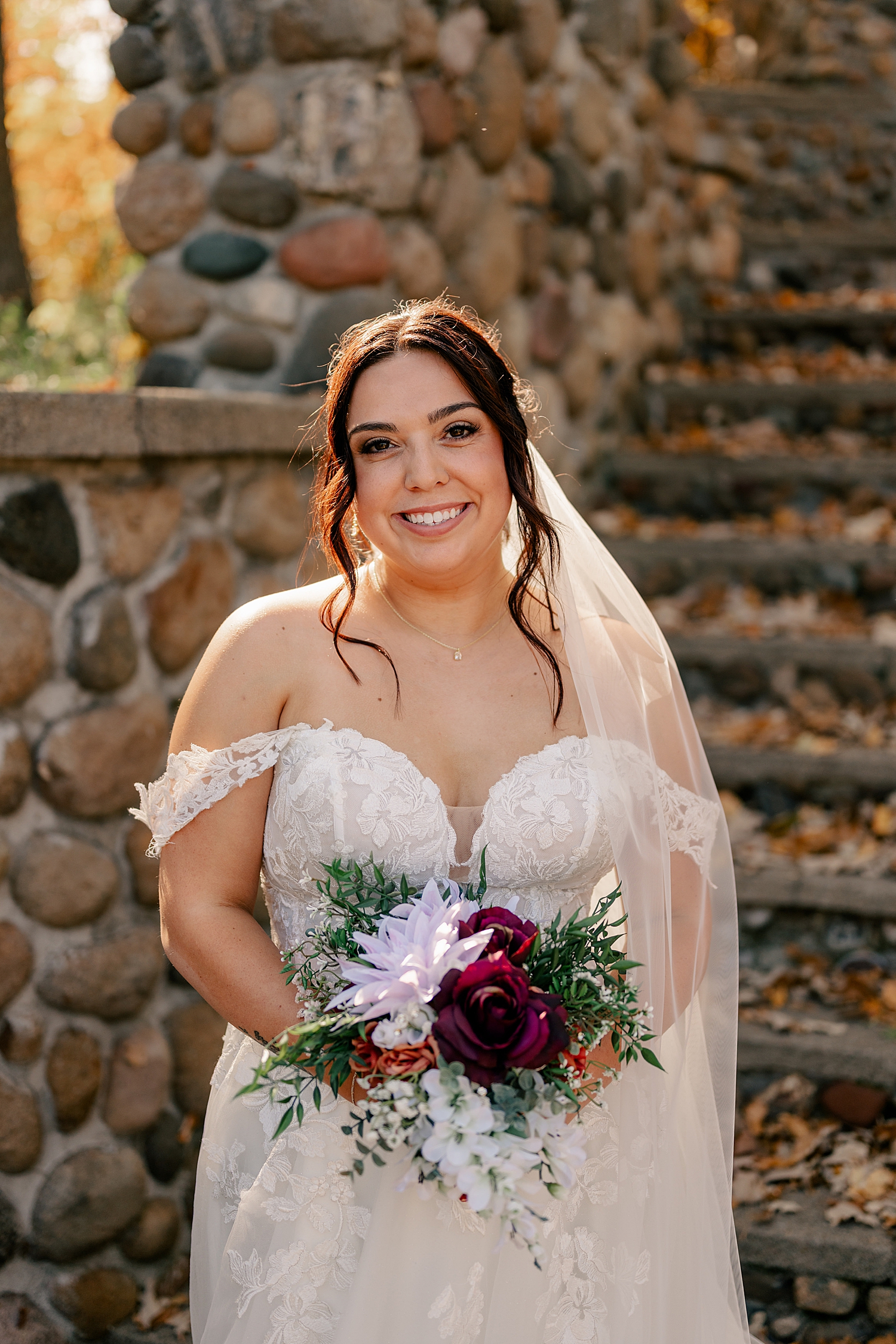 brunette woman in white dress holds flowers by Rule Creative Co
