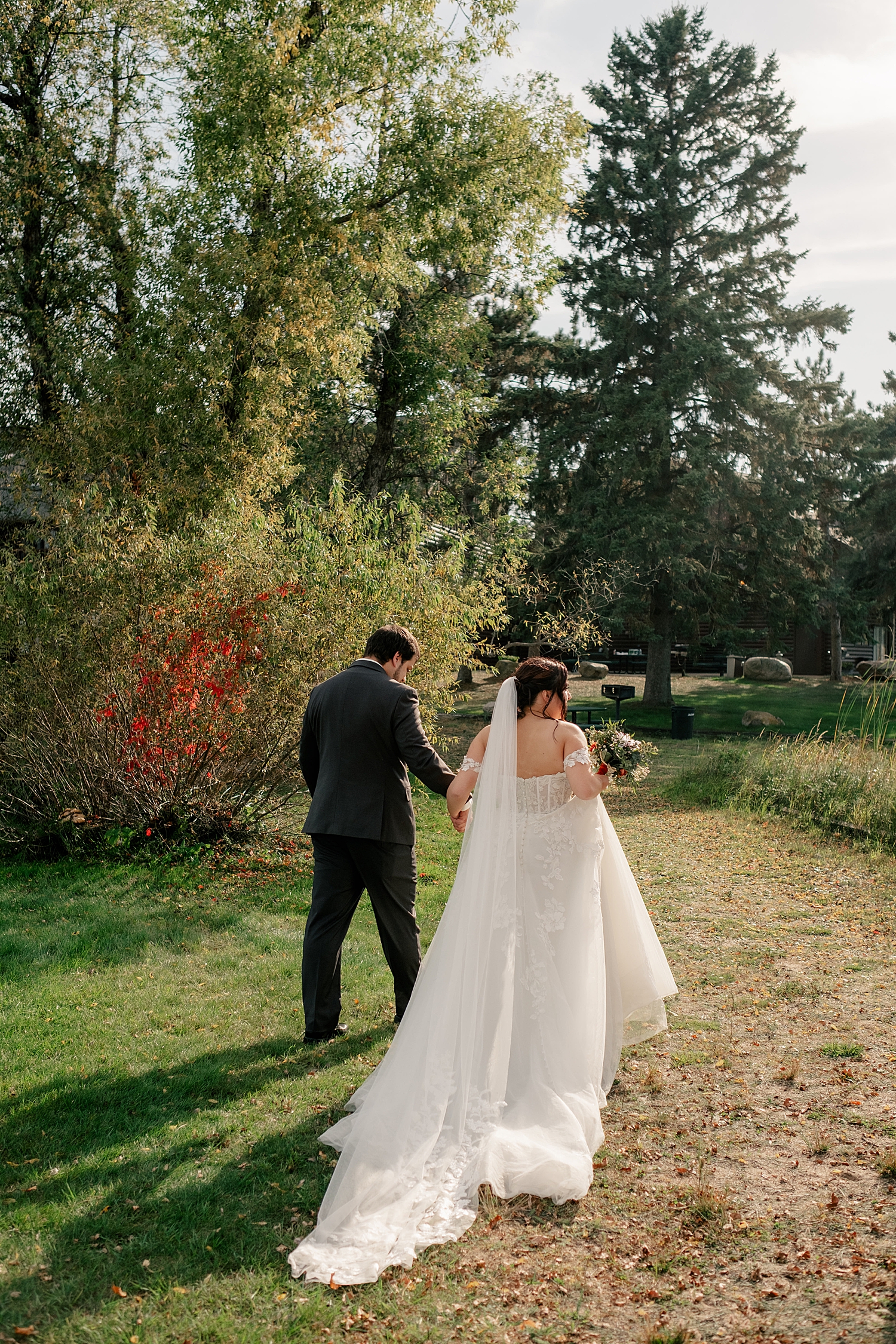 newlyweds walk under Fall trees by Rule Creative Co