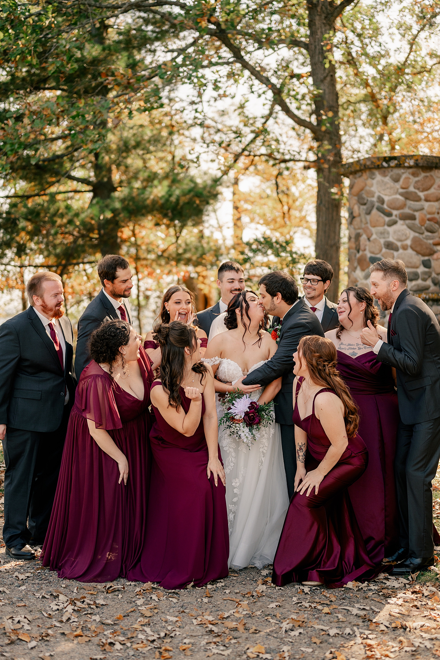 bridal party in wine color dresses surround newlyweds at Breezy Point venue
