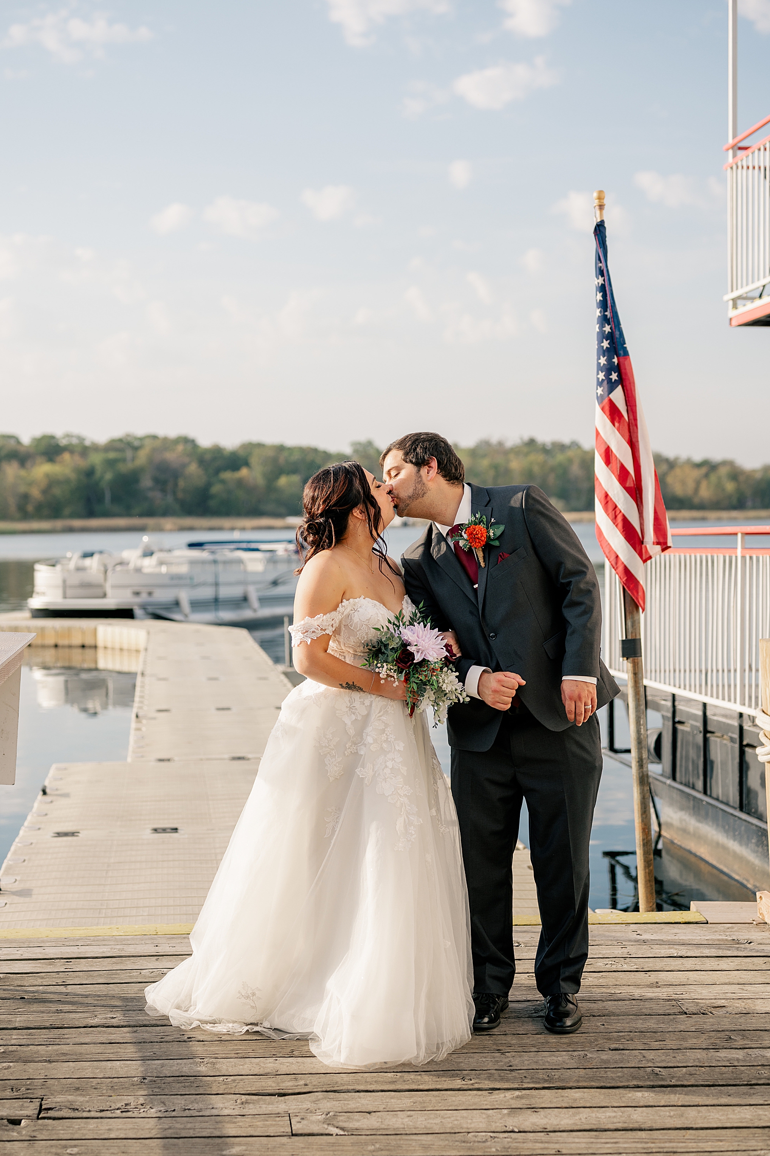 newlyweds share a kiss on the dock by Minnesota wedding photographer